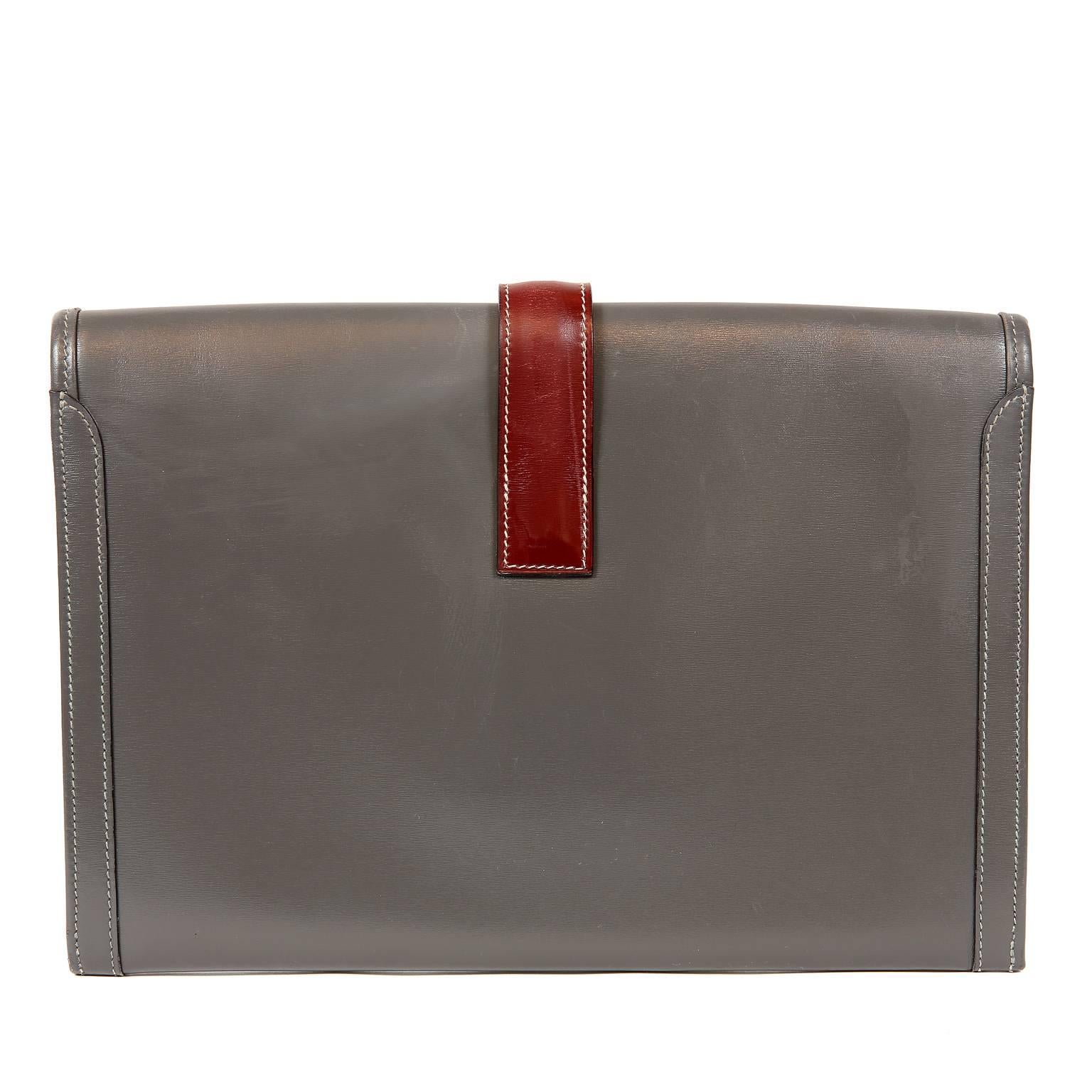  Hermès Grey and Bordeaux Leather Jige Clutch- Very Good Vintage Condition
From the mid 80’s, this classic vintage Hermès has some light scuffs and scratches.  Please review photos. 
Grey leather slim clutch has contrasting burgundy leather H belted
