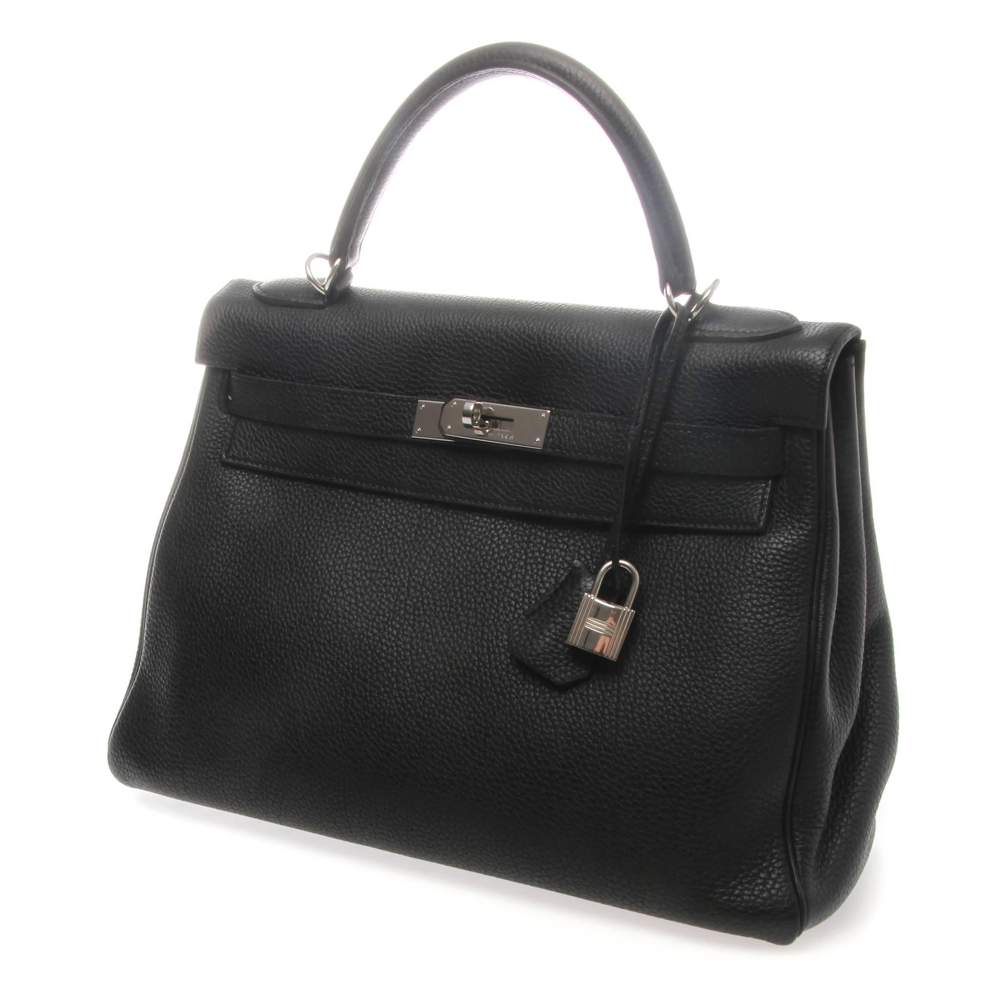 	
Hermès Kelly Retourne 32cm Black Veau Togo with Silver Hardware.

Hermès Kelly 32 Retourne made of black veau togo leather; a highly resilient leather. 
It features a flap closure with signature padlock and cloche, zip pocket and two open pockets