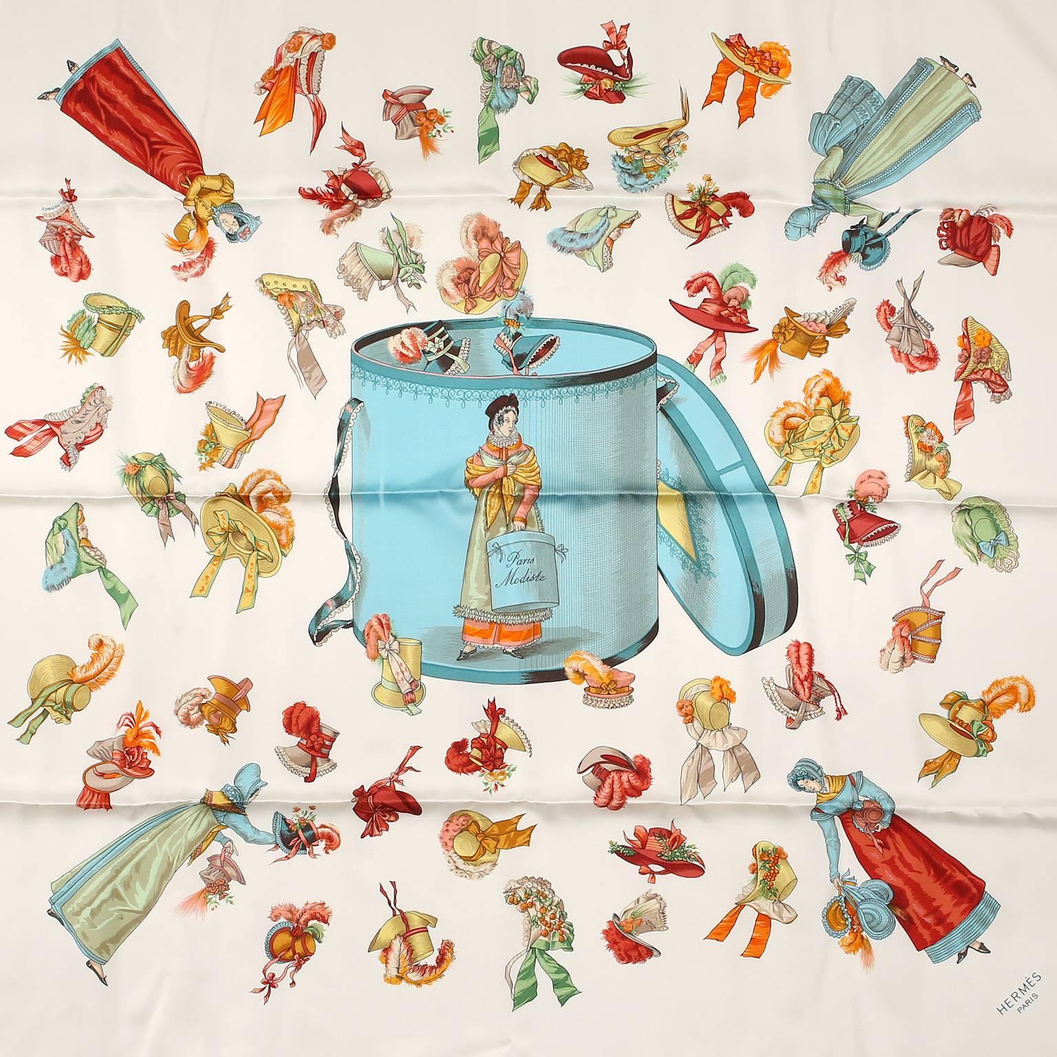 Hermès Paris Modiste 90 cm Silk Scarf - PRISTINE
  Designed by Hugo Grygkar and first issued in 1956, it is considered highly collectible.
White background with a robin’s egg blue hat box as the centerpiece.  “Modiste” translates to milliner, or hat