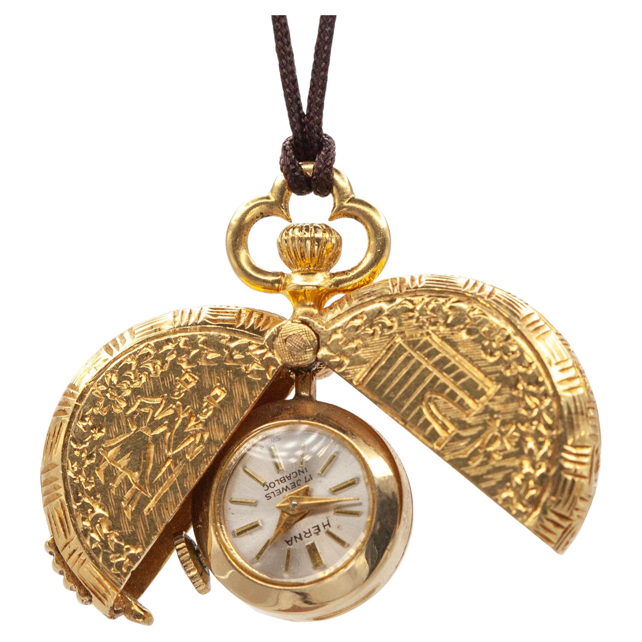 Vintage Herna 14K yellow gold pocket watch pendant with 18K yellow gold engraving on both side hinged cover and a 17 jewels incabloc shock protection Swiss made manual wind movement from 1960s

Approximate Weight: 19.6 grams

Approximate