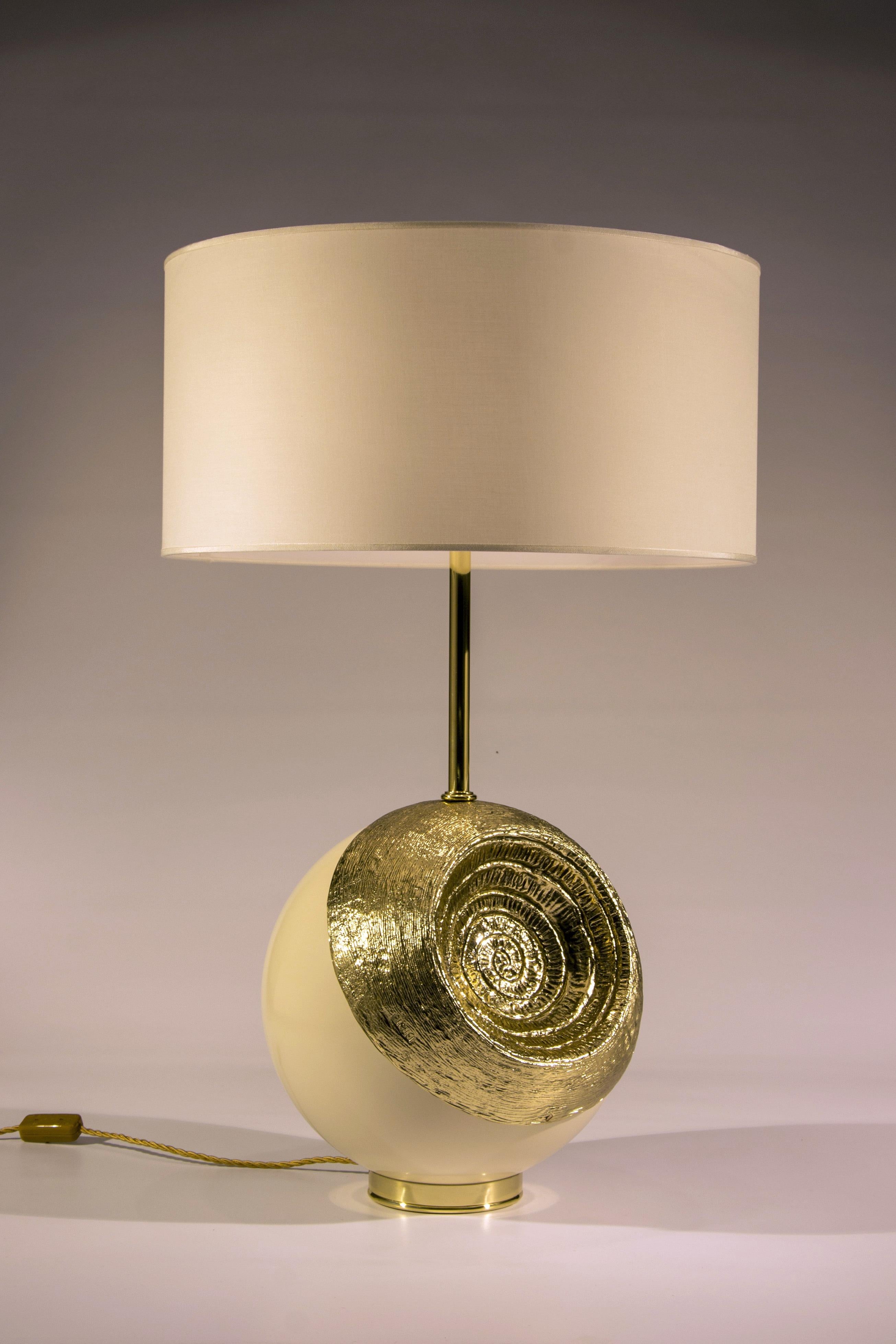 Lamp with important sculpture base in artistic brass casting. Originally the sphere at the base was conceived by Angelo Brotto in 1977 as a table sculpture. The rear part of the sphere is available in the brass version (as in the photo) and in the