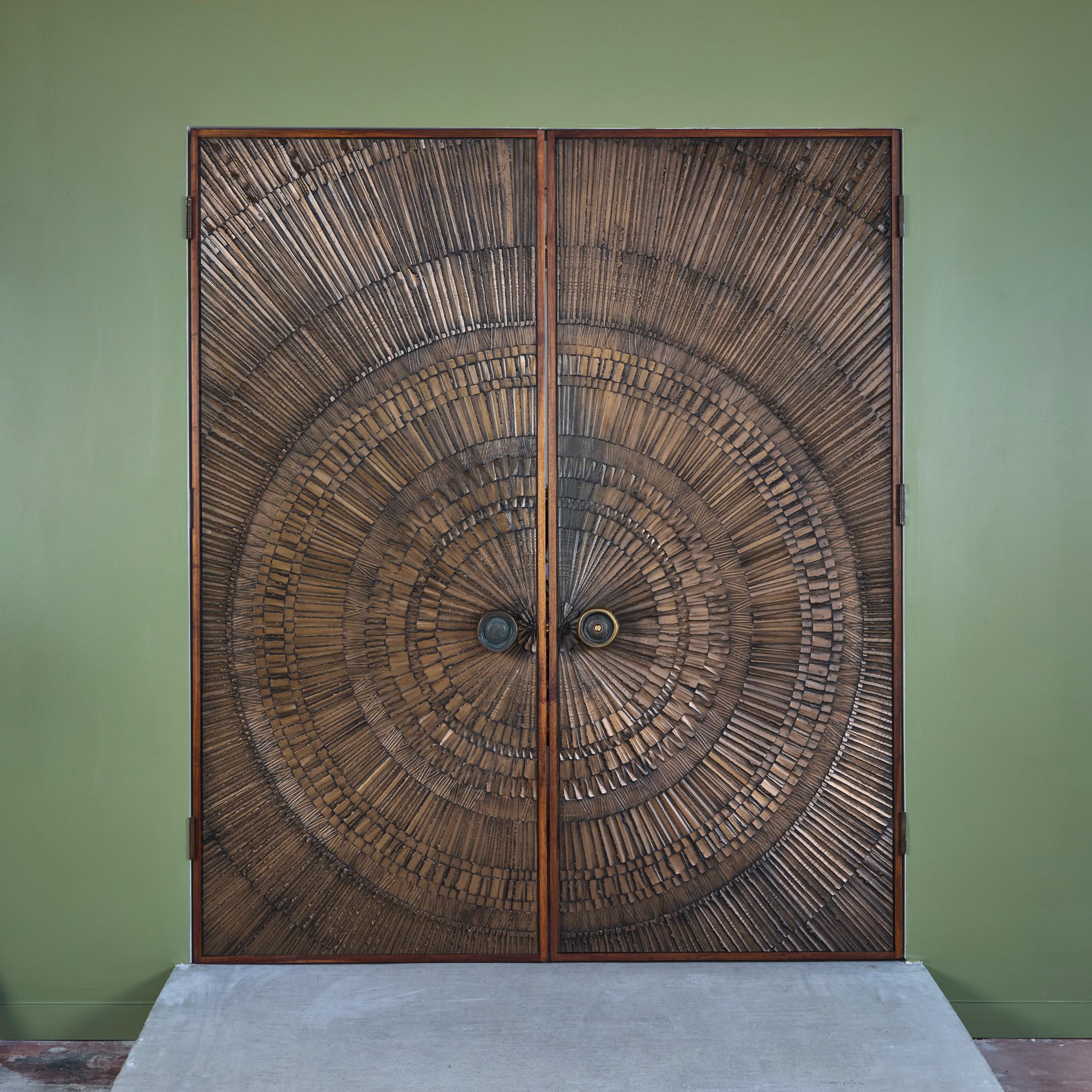 Coppia di porte doppie in bronzo fuso di Billy Joe Mccarroll e David Gillespe per Forms and Surfaces, anni '70 circa, USA. Questa coppia di porte presenta un motivo a raggi di sole su ciascun lato e tiraggi rotondi.

Dimensioni
Ogni porta: 36