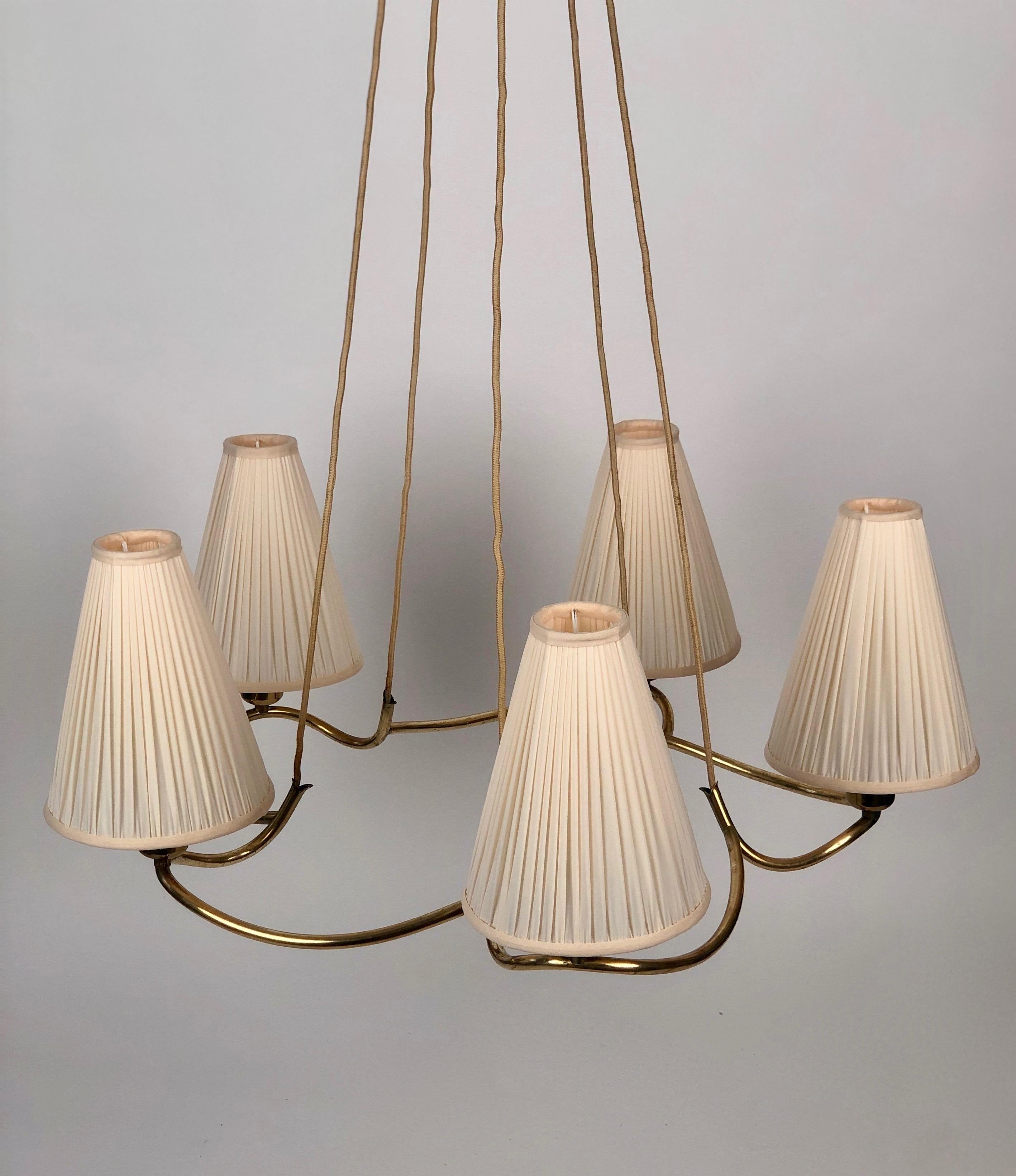 A large ceiling lamp with five silk shades . The Heron lamp was produced by J.T. Kalmar in the 1930's . We have renewed the shades with silk textile using the existing frames.
The electric has been controlled.

The brass frame has a patina that