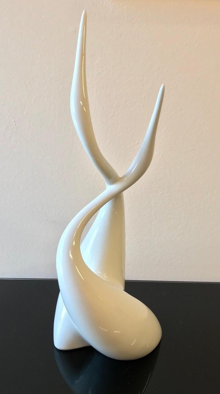 Cette élégante et fine sculpture figurative en porcelaine Royal Dux a été produite en République tchèque en 1958. Elle présente un design moderne de Jaroslaw Jezek représentant deux hérons stylisés entrelacés. 
Signé sur la base.
Dans des conditions