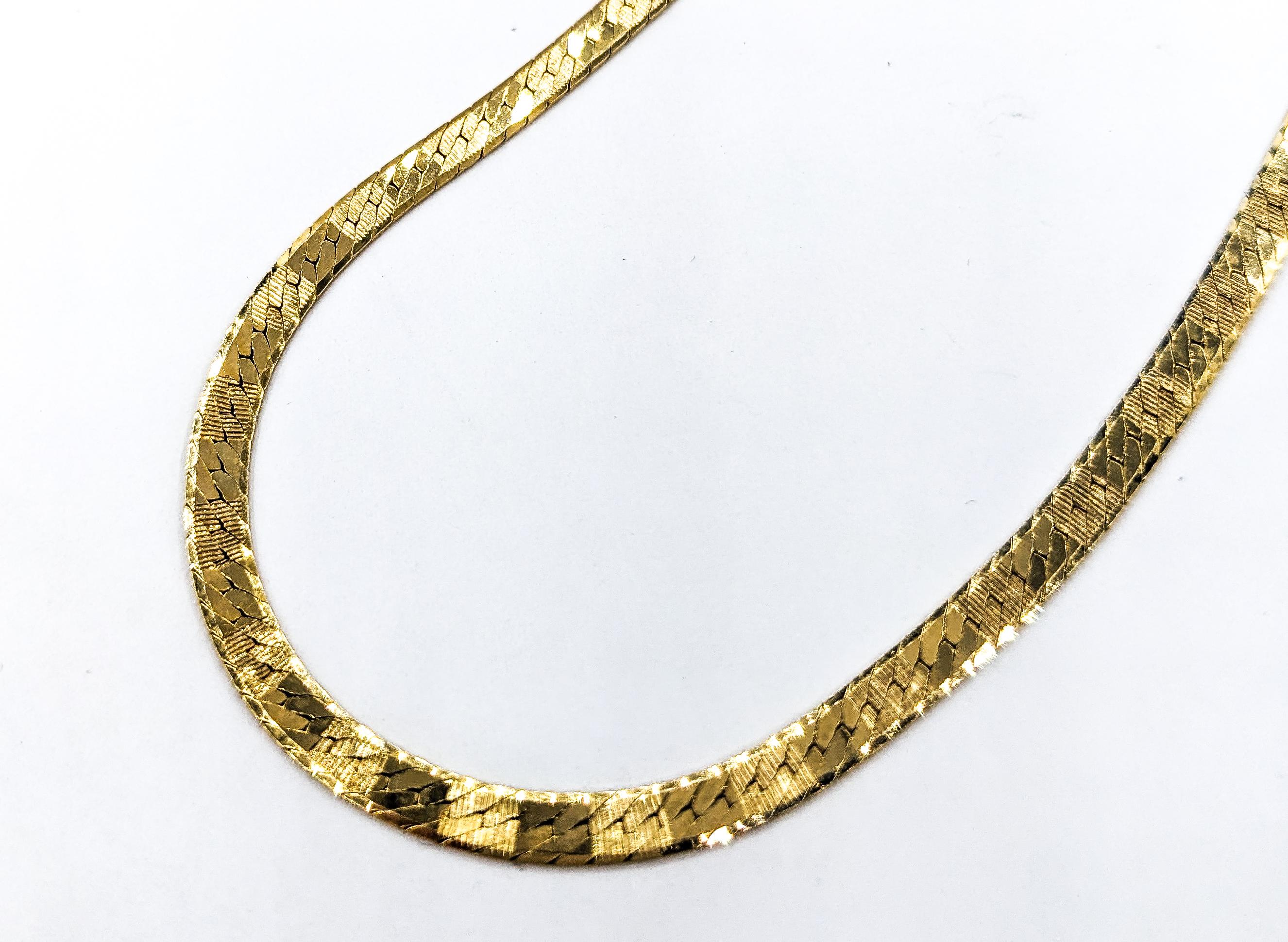 Herringbone Design Necklace In Yellow Gold

This stunning gold fashion necklace, meticulously crafted in 14kt yellow gold, features a striking herringbone textured design that elegantly reflects light, showcasing a brilliant sheen that captures the