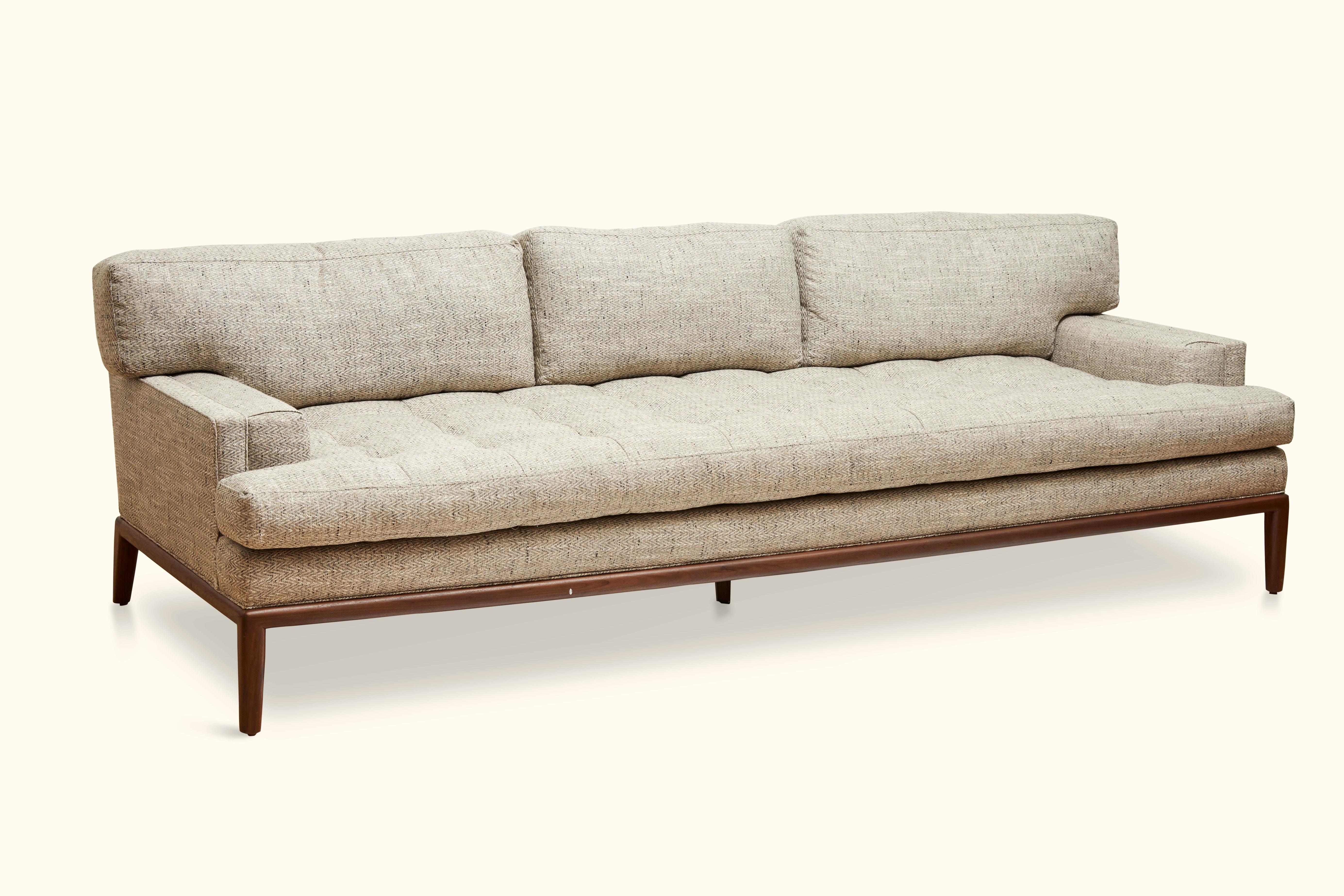 The Forster sofa is a midcentury-inspired sofa with a loose tufted seat, loose back cushions, and piped details. The sofa rests atop a simple, rounded wood base. Shown here in herringbone upholstery and a Natural Walnut Base. 

The Lawson-Fenning