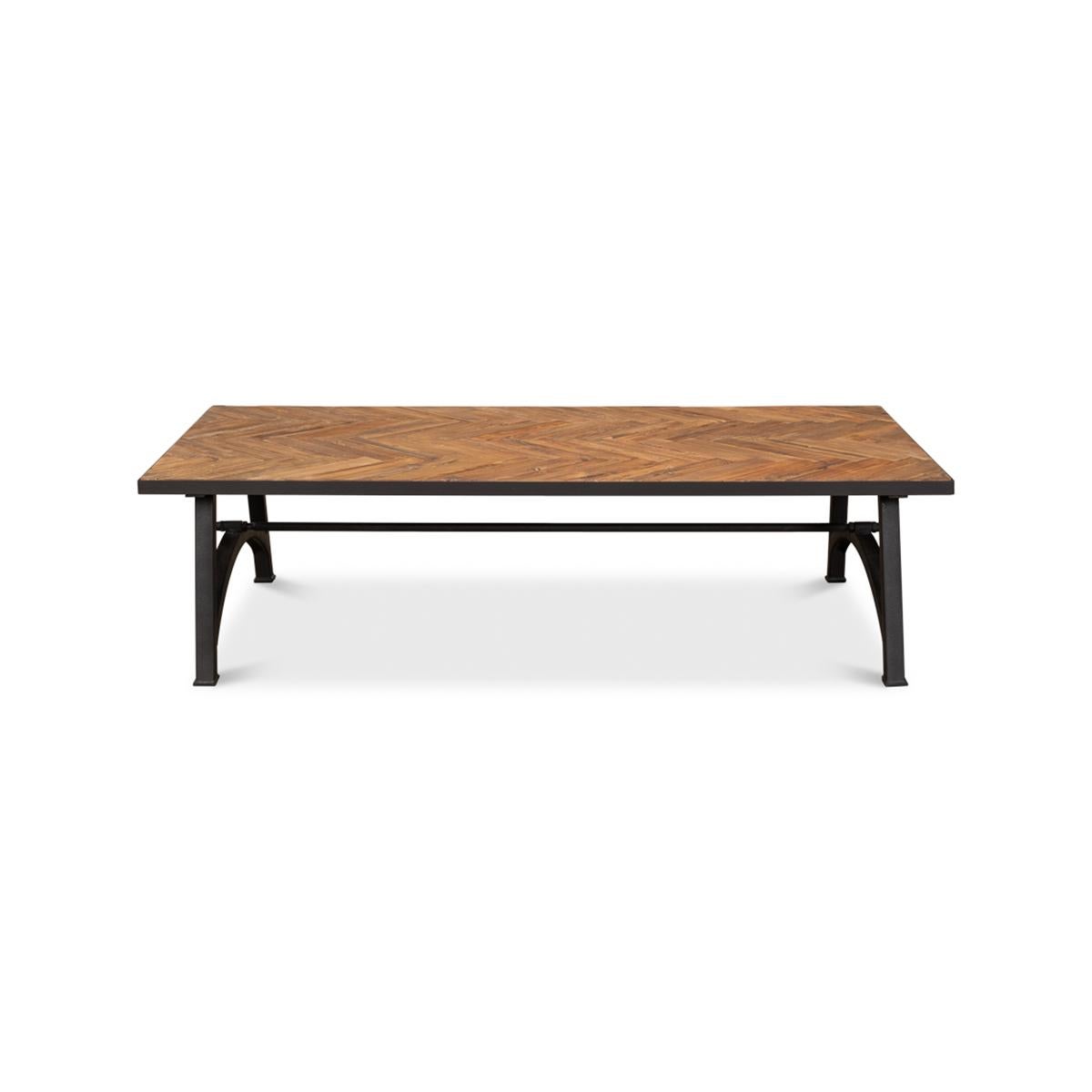 Made with reclaimed wood, this large coffee table features a herringbone parquetry inlaid wooden top. Raised on an iron strecher base that provides a sturdy architectural design.

Dimensions: 67