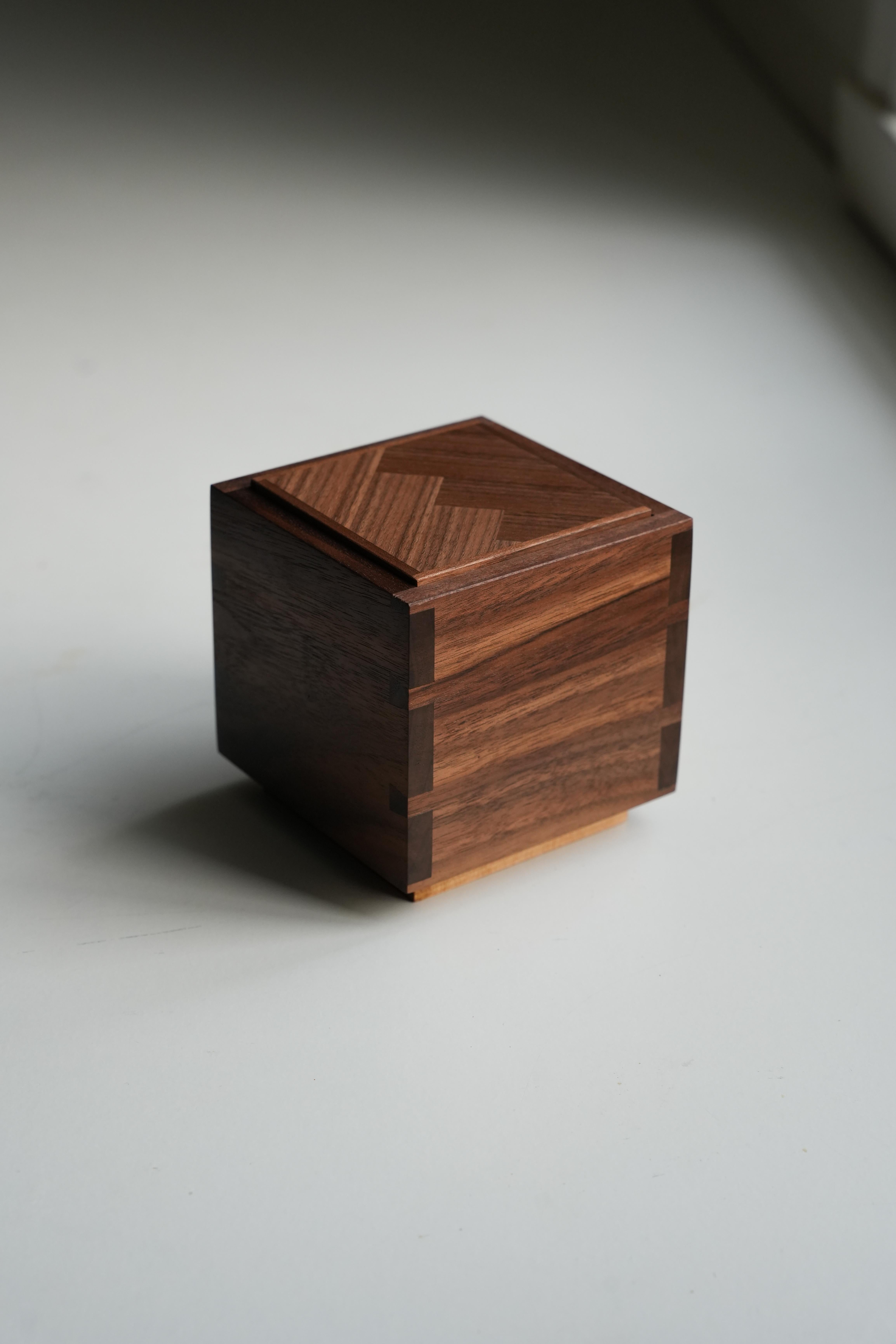 Handmade Wooden Box with Push-Up Function

This wooden box is made with dovetail joints for durability and a refined finish. The outer box is crafted from walnut, and the inner box is made of birch. The lid features a walnut herringbone pattern, and