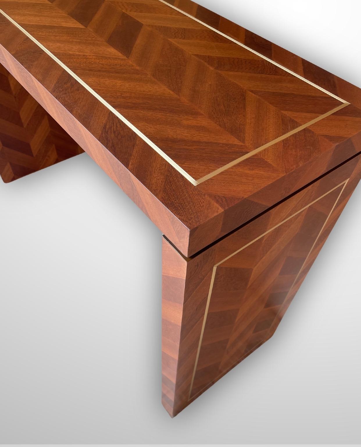 Trasforma il tuo spazio con il tavolo consolle Herringbone Wood, una consolle in legno massiccio realizzata a mano che si distingue per il suo design raffinato e la sua lavorazione artigianale di qualità superiore. Realizzata in pregiato legno di
