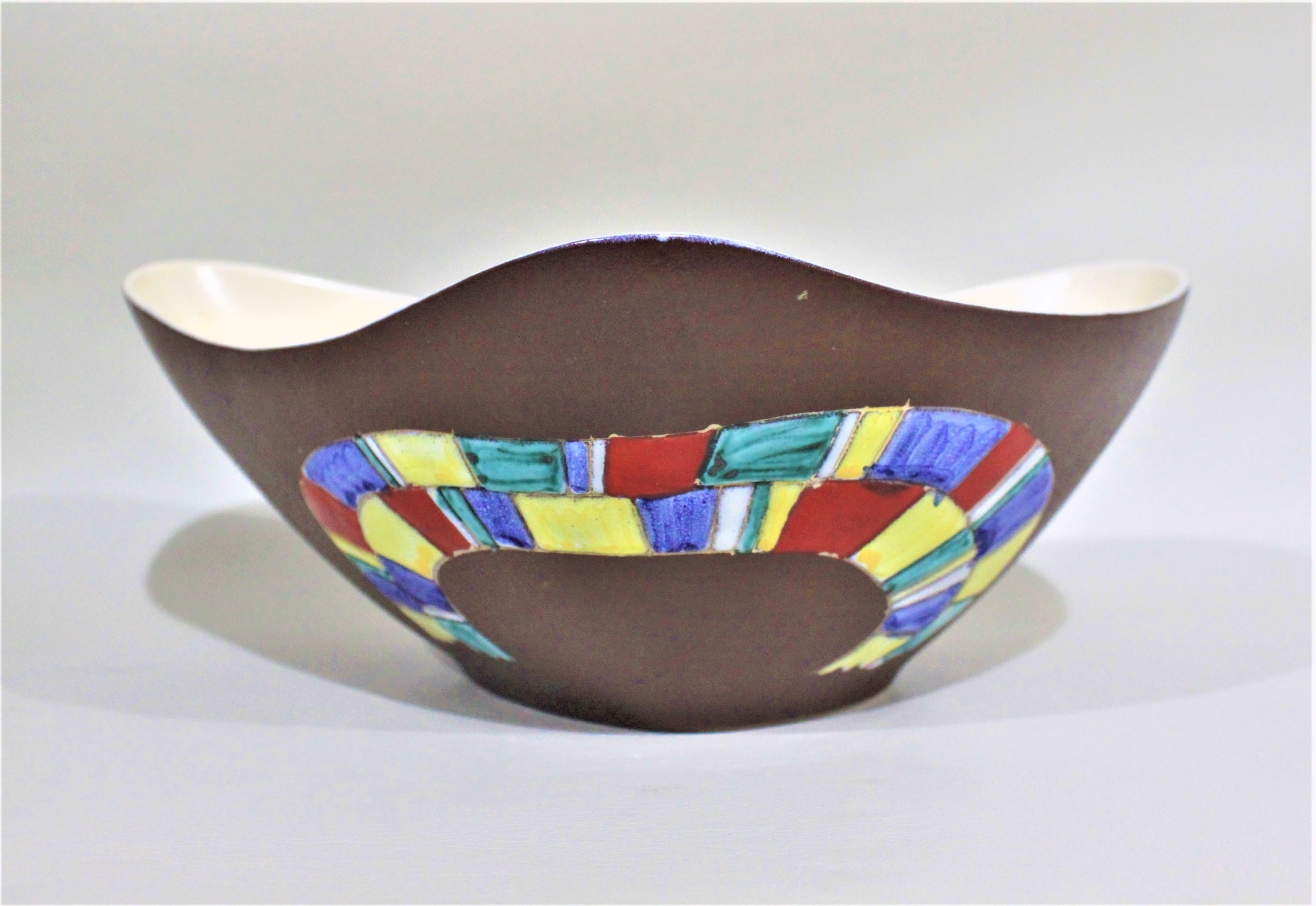 This Mid-Century Modern art pottery bowl was produced in approximately 1965 by Hand Decor of British Columbia Canada, and designed by Herta Gerz. The bowl is somewhat triangular in shape with rounded corners and sweeping curves between each point.
