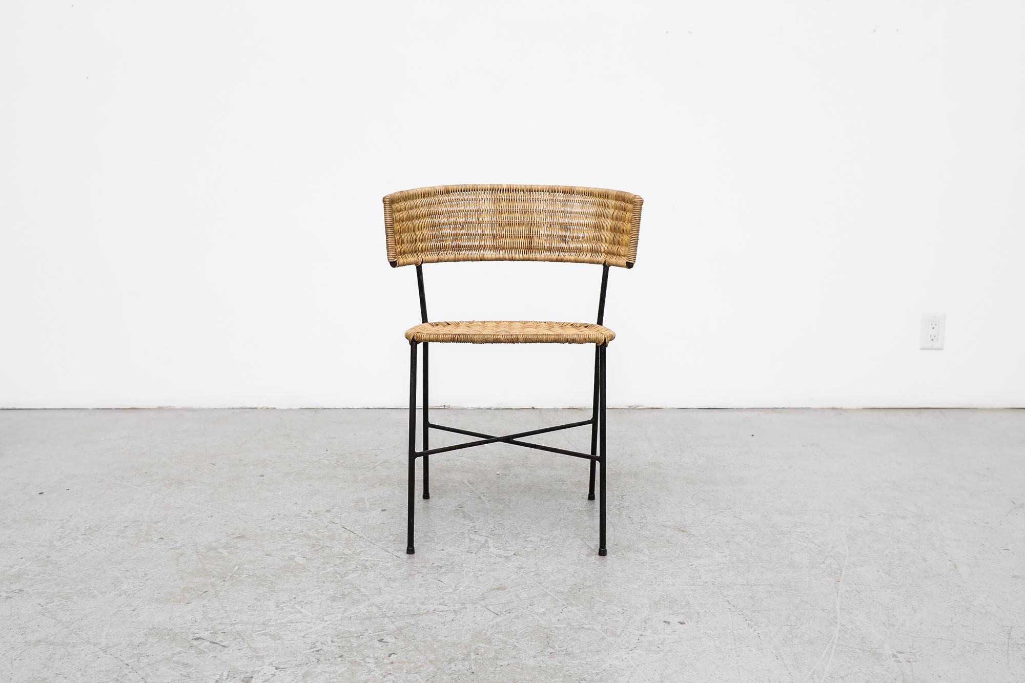 Mid century Herta-Maria Witzemann style rattan accent chair with elegantly curved rattan wrapped seat back, simple flat woven seat and sturdy yet elegant black enameled metal frame. In original condition with wear and patina that is consistent with