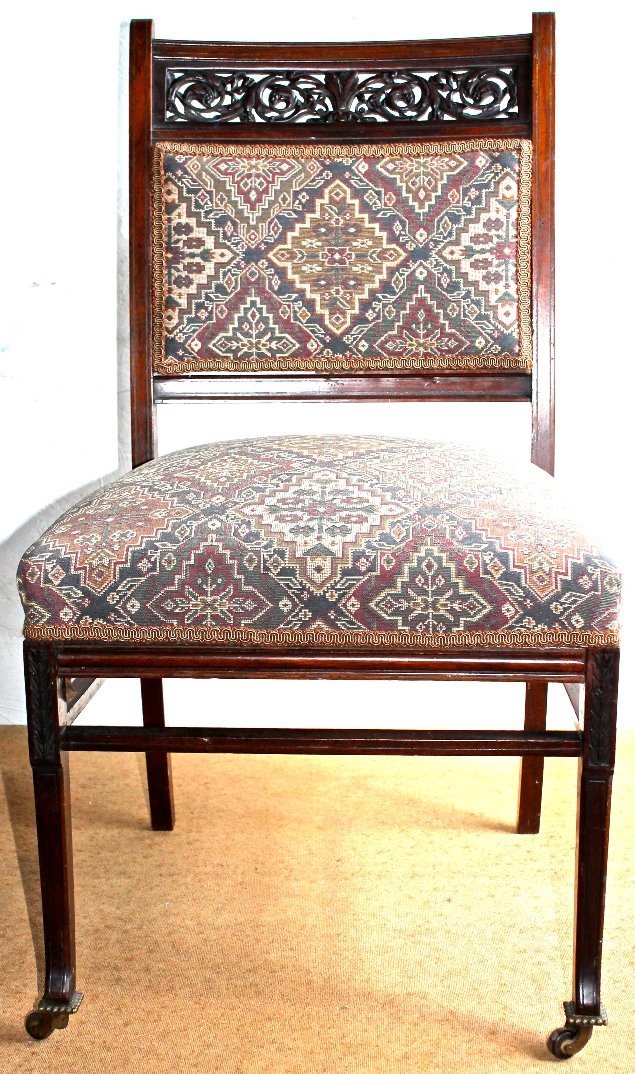 Important chair in fine woods with brass inlay and fine detailed carving on crest and front of legs. Chair's two front legs equipped with India Rubber Comb Co. New York Casters. Upholstery new, as found.