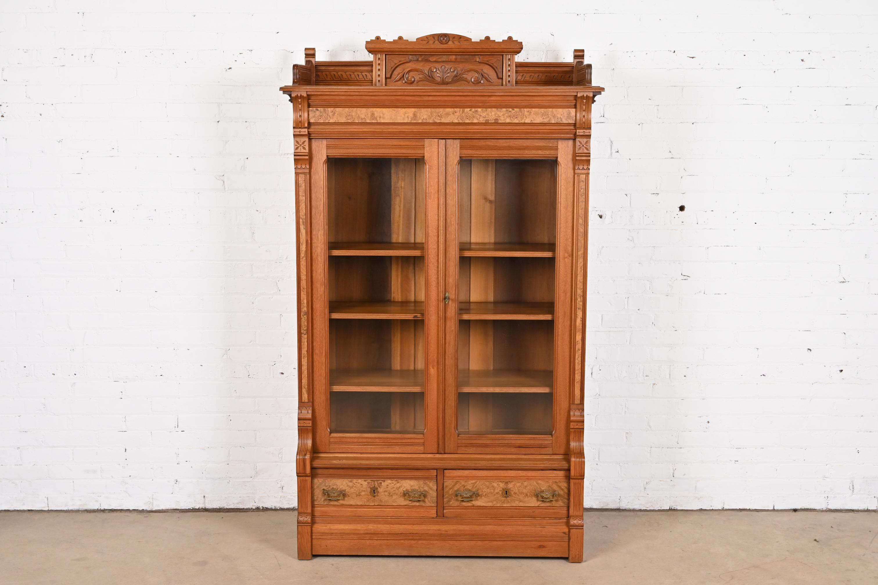 An exceptional antique Eastlake Victorian bookcase

In the manner of Herter Brothers

USA, Circa 1860s

Carved walnut, with burled walnut front and original brass hardware.

Measures: 44.25
