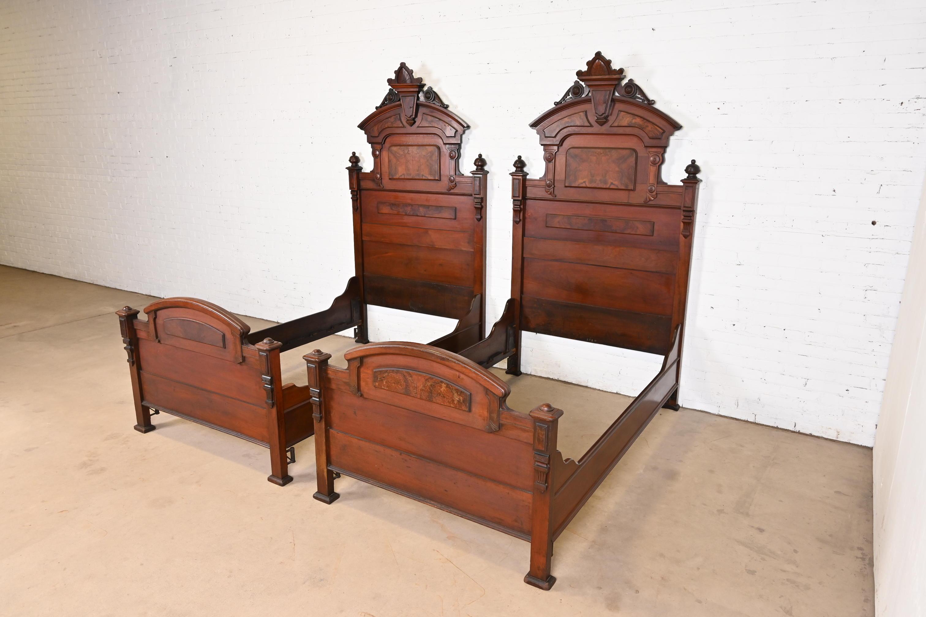 A rare and outstanding pair of monumental antique Eastlake Victorian twin size bed frames

In the manner of Herter Brothers

USA, Circa 1880s

Carved solid walnut, with burled walnut panels.

Each measures: 48