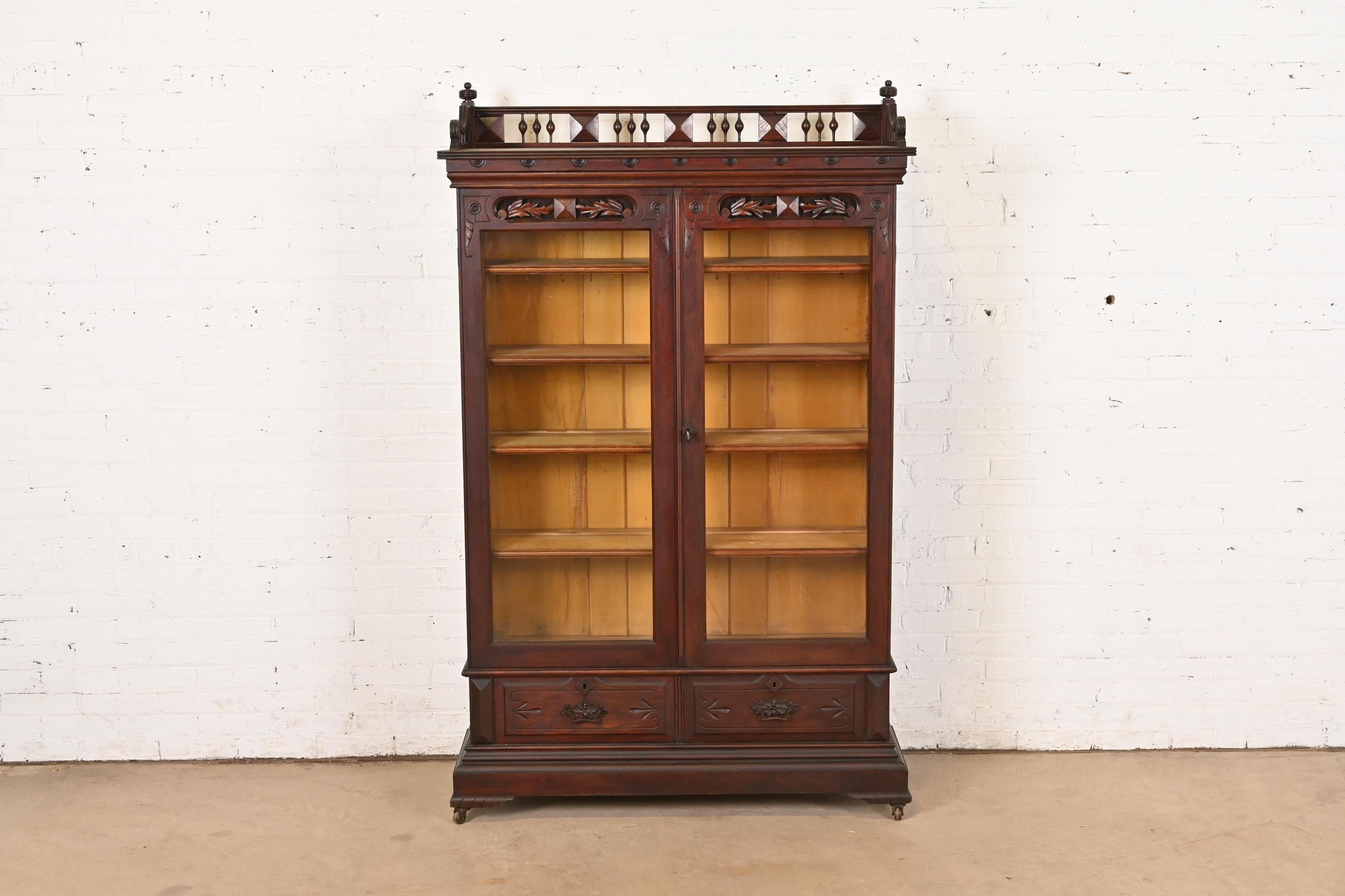 An exceptional antique Eastlake Victorian bookcase cabinet

In the manner of Herter Brothers

USA, Circa 1880s

Carved walnut, with glass front doors, and original hardware. Cabinet locks, and key is included.

Measures: 44.75