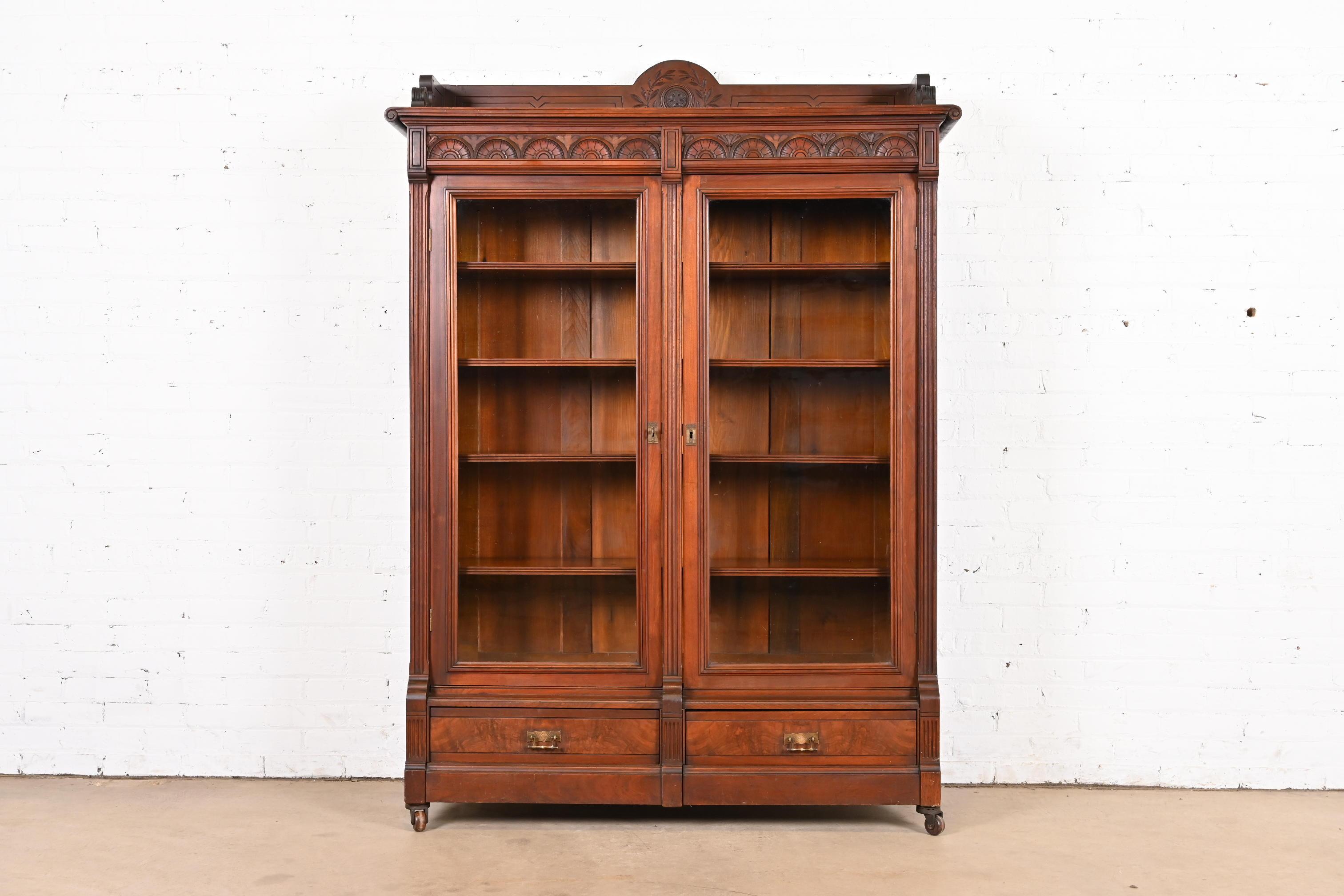An exceptional antique Eastlake Victorian bookcase

In the manner of Herter Brothers

USA, Circa 1880s

Carved walnut, with burled walnut drawer fronts, glass front doors, and original brass hardware. Shelves are adjustable.

Measures: 52.38