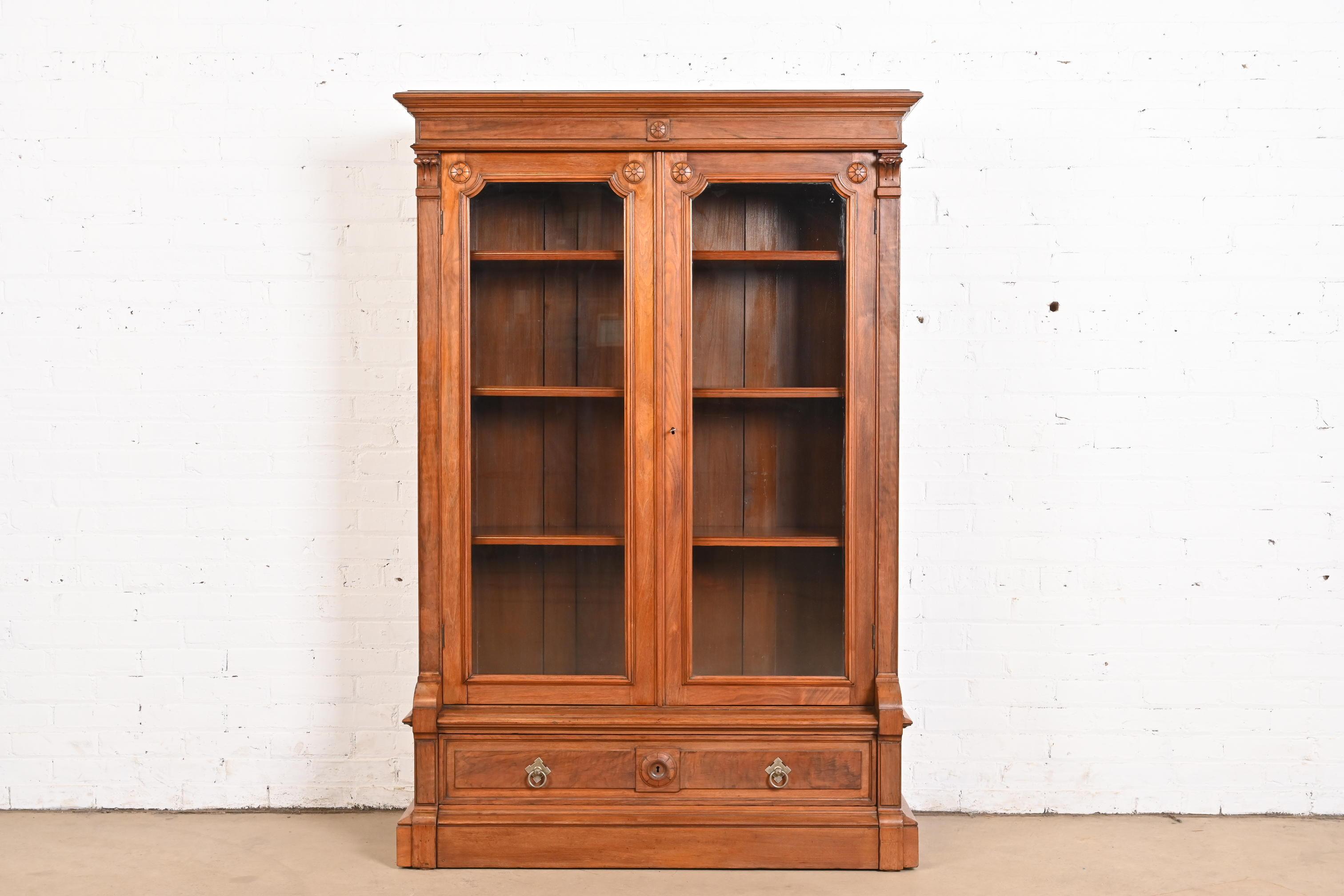 Magnifique bibliothèque victorienne Eastlake antique

À la manière des frères Herter

États-Unis, vers 1880

En noyer sculpté, avec des panneaux en noyer ronce, des portes vitrées et des ferrures en laiton d'origine. Les étagères sont réglables. Clé