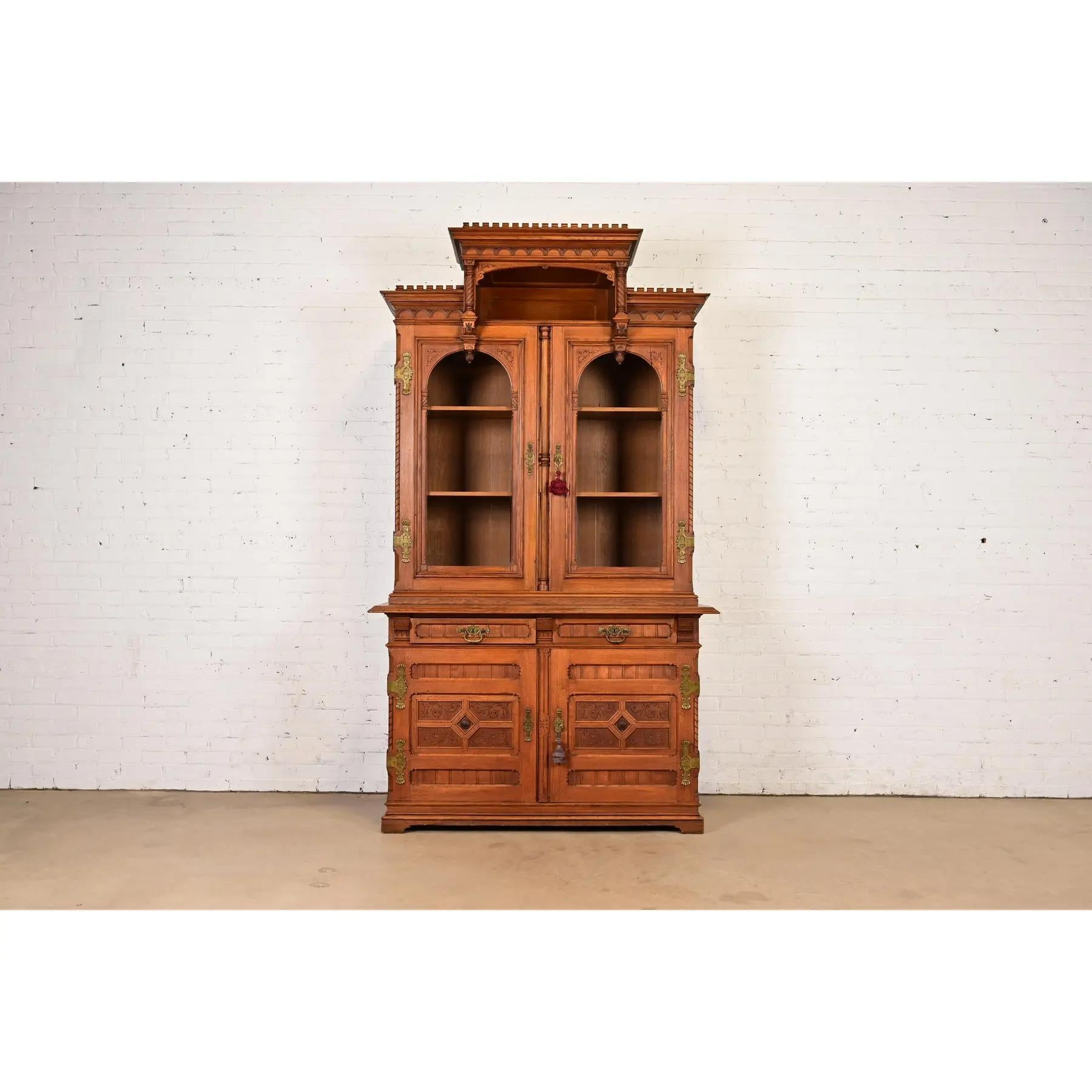 Magnifique bibliothèque, armoire ou meuble de bar ancien de style victorien ou néo-gothique à façade brisée. 

À la manière des frères Herter

États-Unis, vers 1880

Chêne sculpté et orné, avec quincaillerie en laiton d'origine. L'armoire se