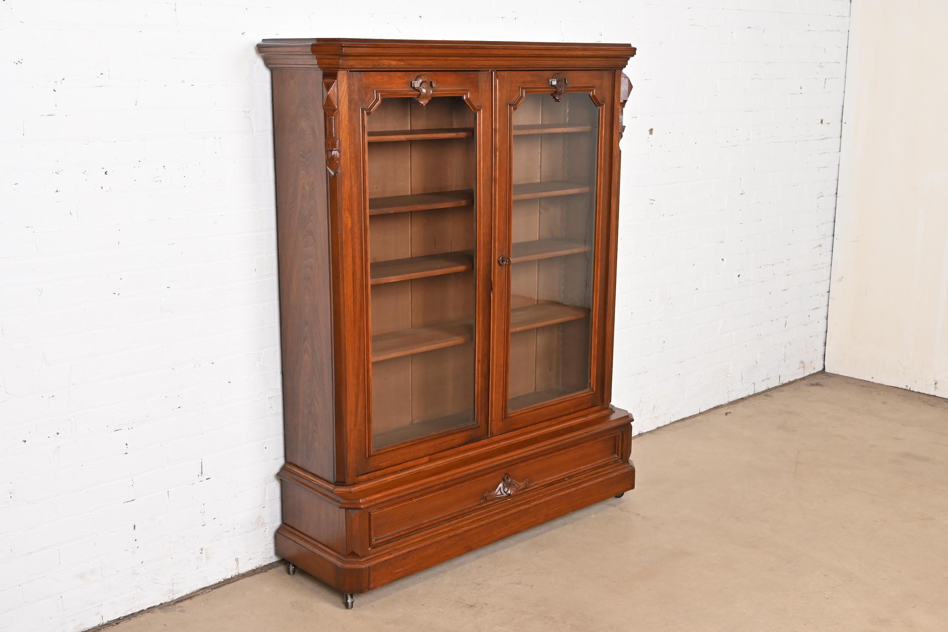 Américain Bibliothèque victorienne ancienne en noyer sculpté avec façade vitrée, style Herter Brothers en vente