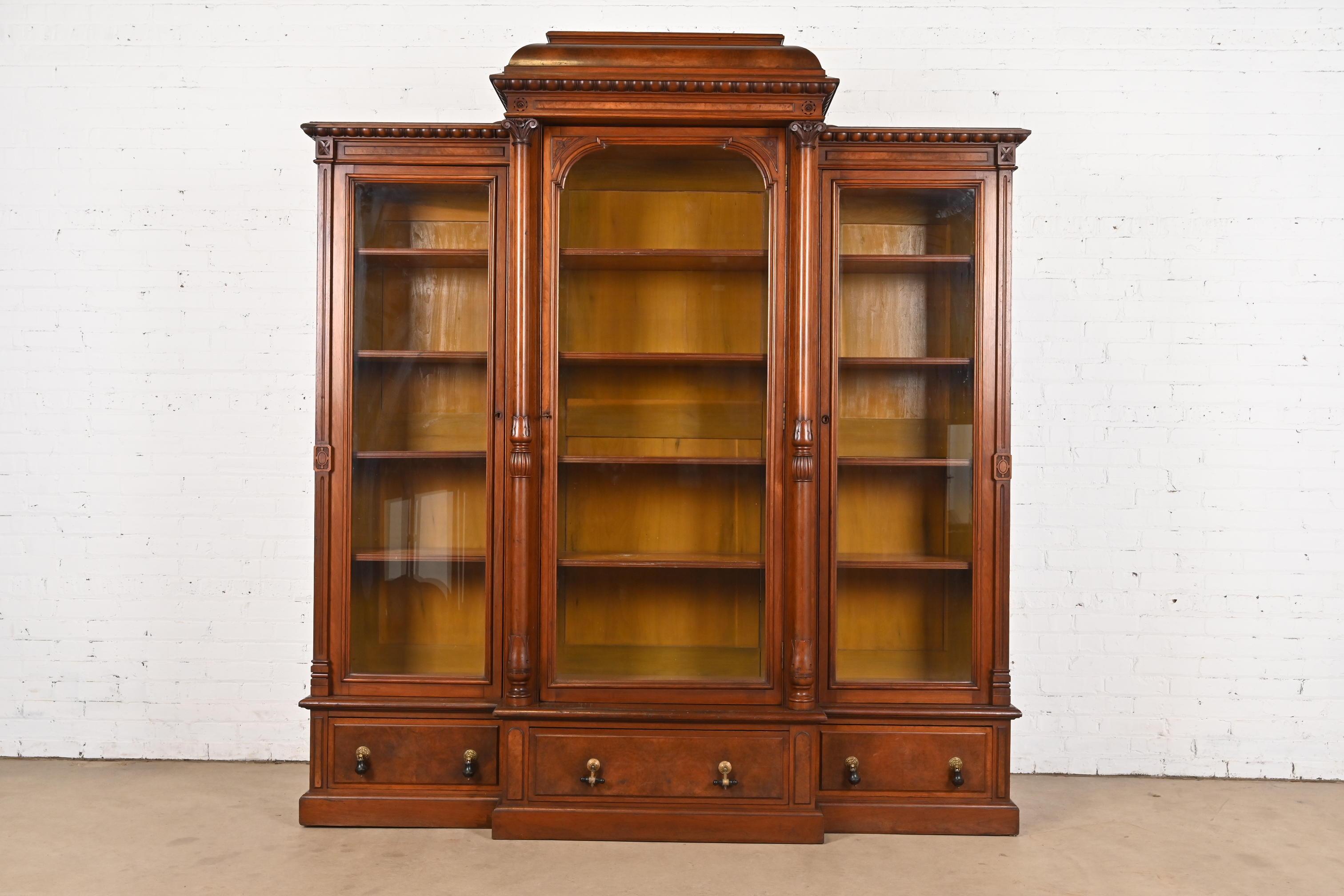 Eine außergewöhnliche monumentale antike Eastlake viktorianischen dreifachen Bücherregal Schrank

Nach dem Vorbild der Gebrüder Herter

USA, CIRCA 1880er Jahre

Geschnitzter Nussbaum, mit genoppten Nussbaumpaneelen, Glastüren und originalen