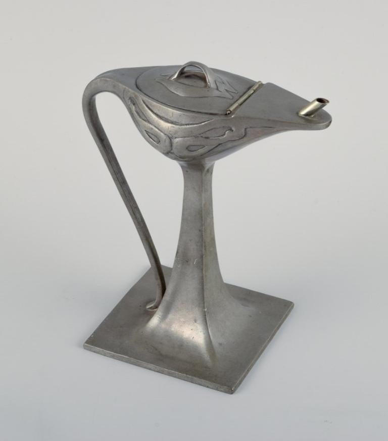 Hertz & Ballin, handmade pewter jug/ oil lamp on foot in Art Nouveau style.
Early 20th century.
In excellent condition.
Stamped HB
Dimensions: H 15.5 x D 8.7 cm.
