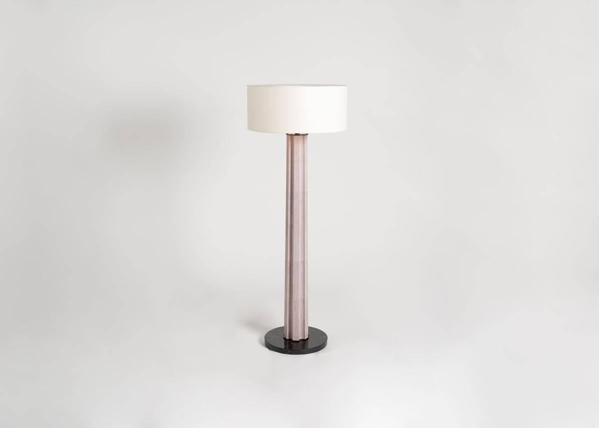 A columnar floor lamp clad in buckskin and resting atop a dark, circular base, Athéna possesses the elegant power of the monolith, and with its ambient glow, generates a quiet, ageless solemnity worthy of its classical namesake. 

Stamped: