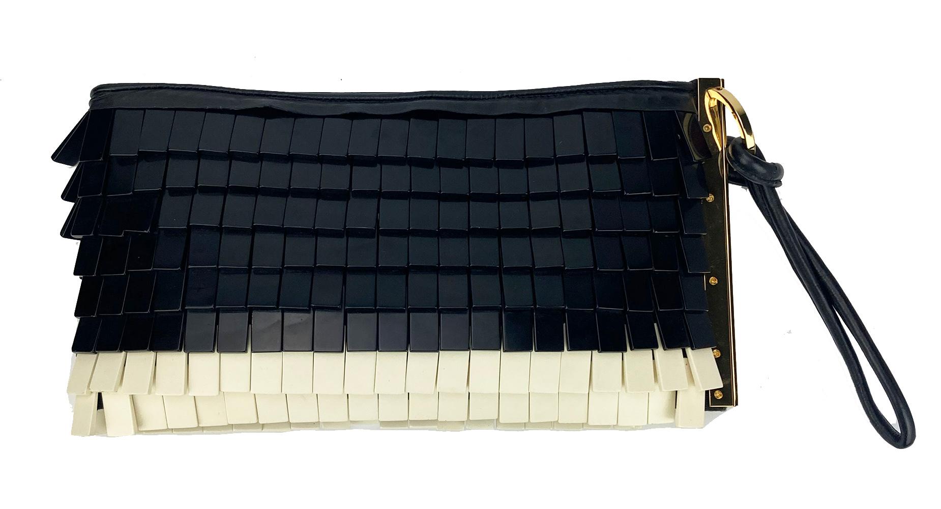 Herve Leger Black and White Acrylic Chip Fringe Clutch in excellent condition. Unique Black and white acrylic small rectangle beads throughout exterior trimmed with black leather and gold hardware. Leather wrist strap. Engraved hardware. Top zipper