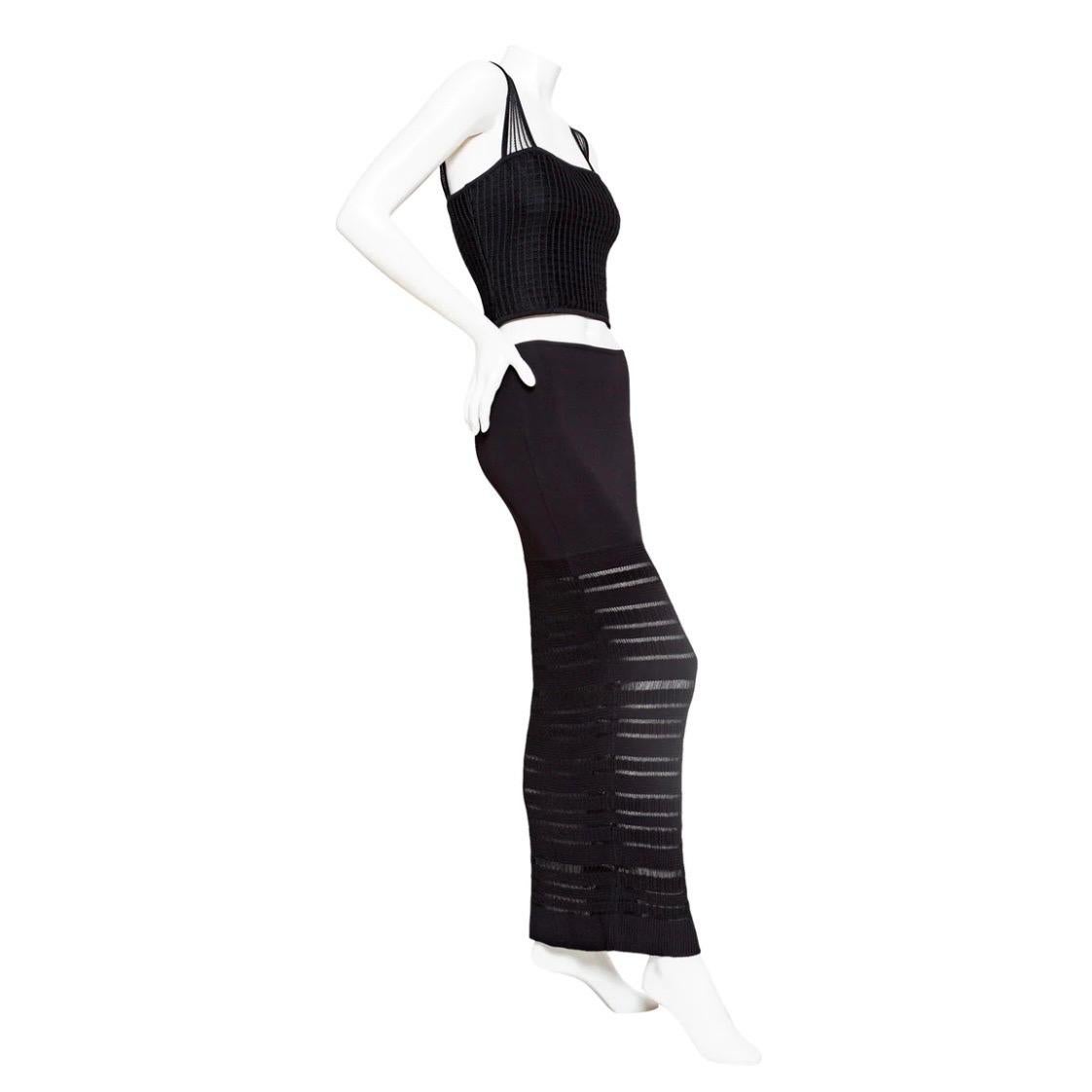 Hervé Léger Black Bodycon Top and Skirt Set

Vintage ; circa 1990
Noir
Tricot extensible tissé
Le top présente de larges bretelles ouvertes en tricot, une encolure carrée, des côtes en forme de boîte, une silhouette légèrement raccourcie et une