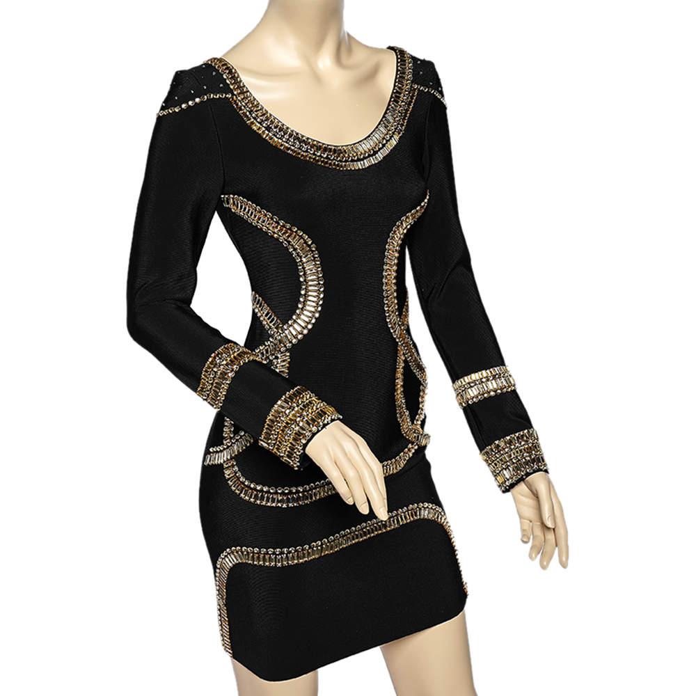 Your party attire is about to look spot-on and opulent with this mini dress from Herve Leger. It is tailored creatively using black stretch knit fabric which is adorned with embellishments. It flaunts a rounded neckline and long sleeves. Wear this