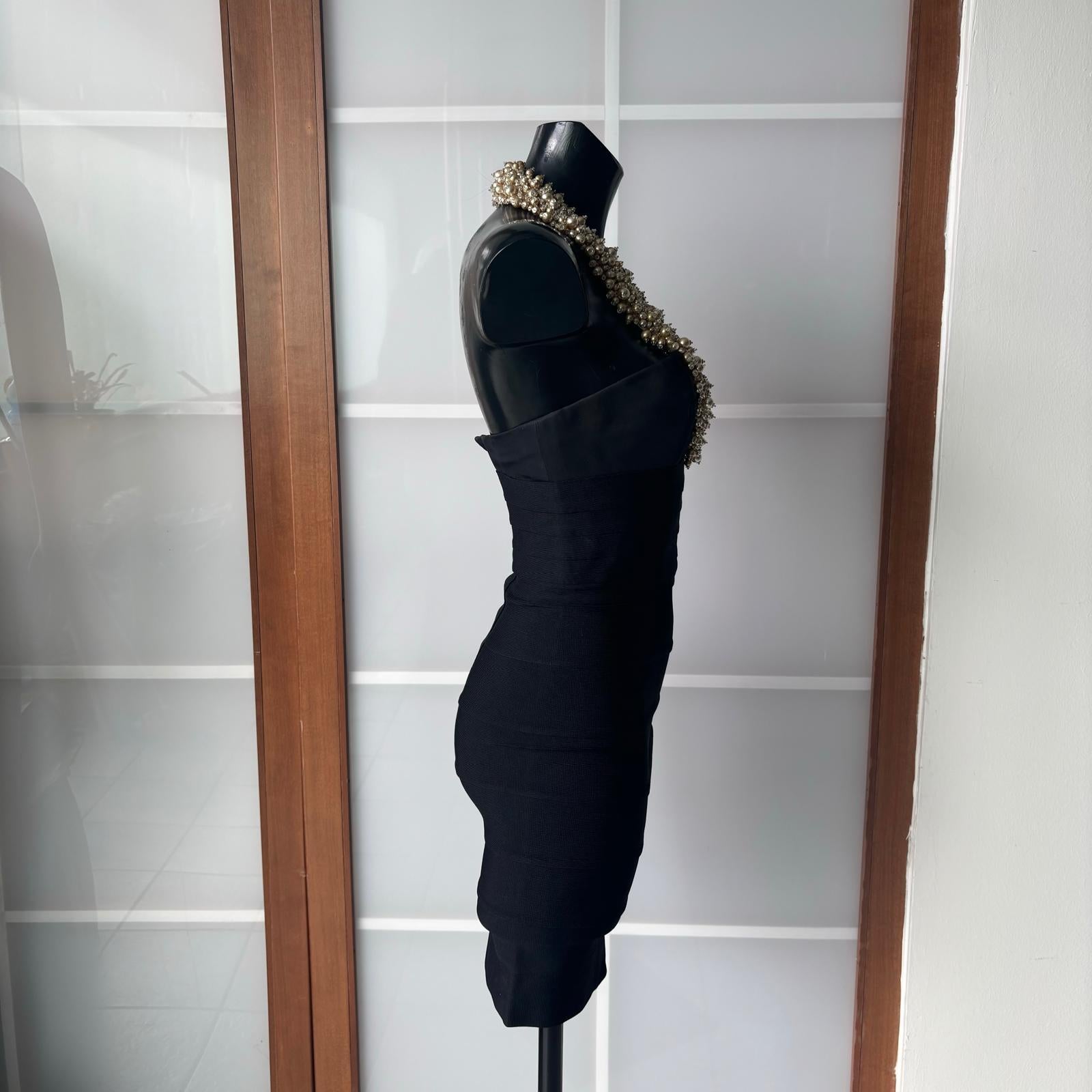 Ein seltenes und exklusives Kleid von Hervé Léger Couture, das in den 1990er Jahren in Frankreich hergestellt wurde und den ikonischen Stil der Marke verkörpert, die die Mode mit ihren berühmten Bindenkleidern revolutioniert hat.

Dieses Modell aus