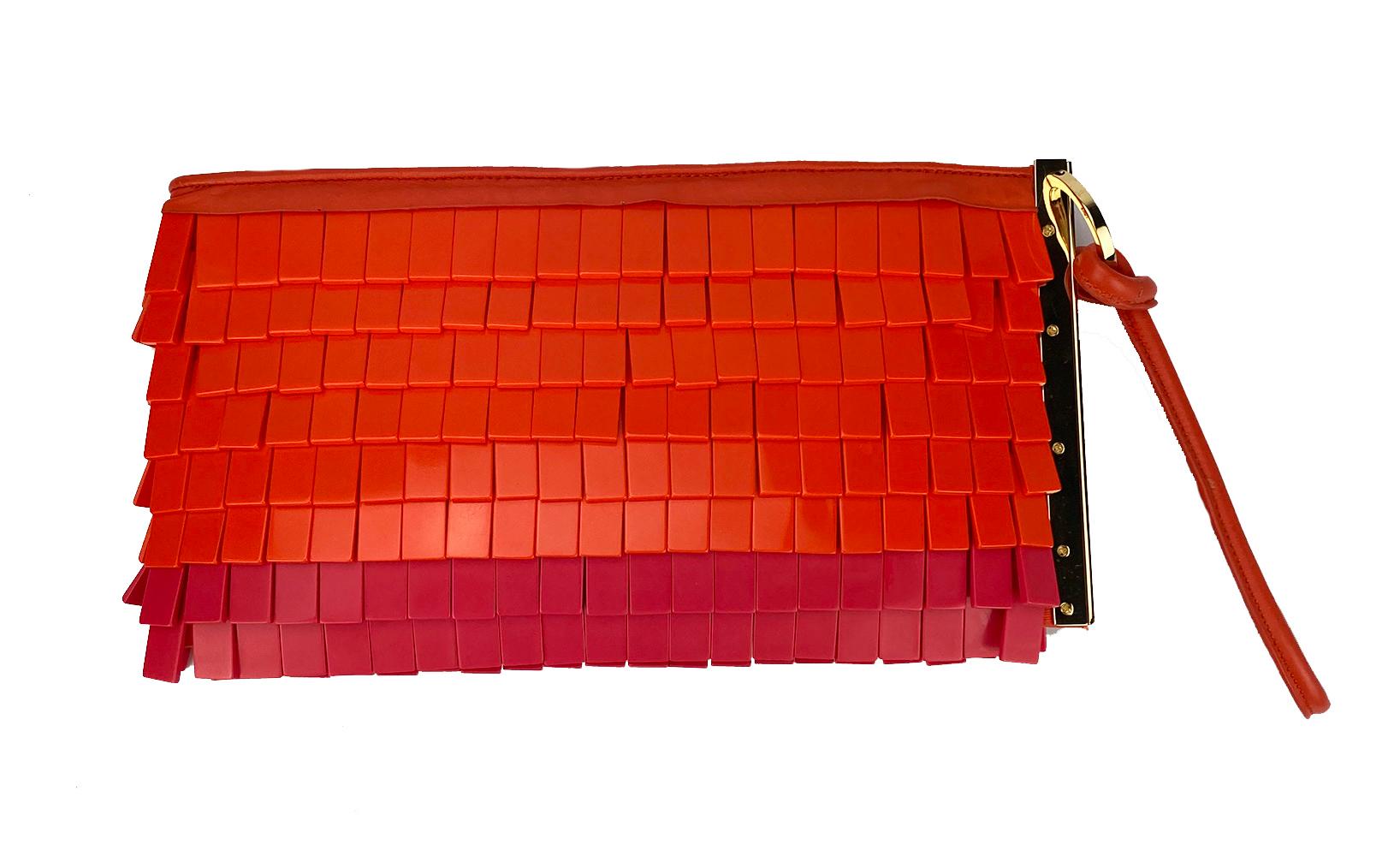 Herve Leger Orange and Pink Acrylic Chip Fringe Clutch in excellent condition. Unique Orange and Pink acrylic small rectangle beads throughout exterior trimmed with pink leather and gold hardware. Leather wrist strap. Engraved hardware. Top zipper