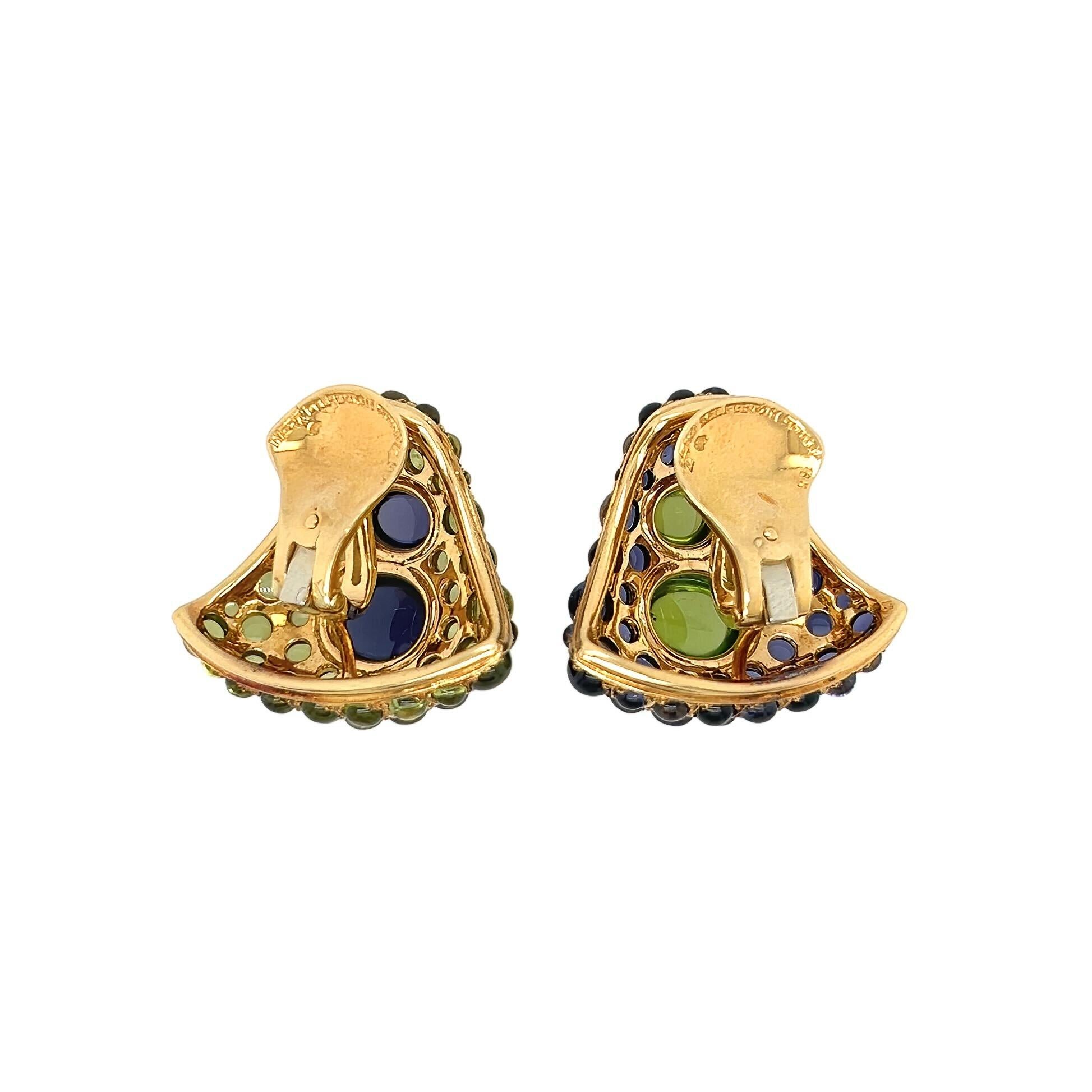A pair of 18 karat yellow gold, peridot and iolite earclips, Herz Belperron, France.  The first earclip designed as a flaring bombe triangle centering two bezel set oval cabochon iolites within a field of round cabochon peridots; the second earclip