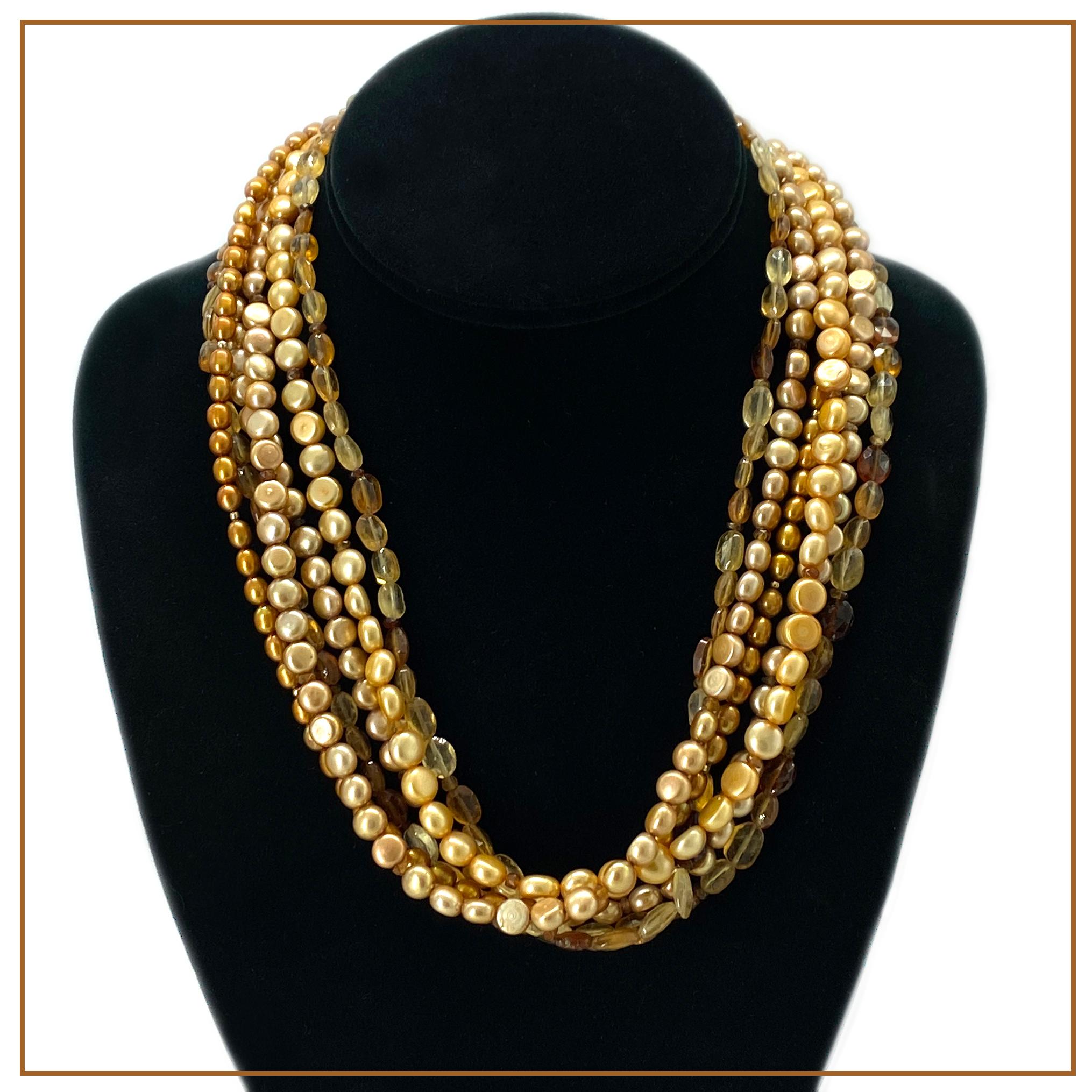 Il s'agit d'un collier à six brins avec des composants en or. Nous l'avons créé avec des perles en forme de bouton de couleur latte et orange, des perles de riz de couleur cuivre et un grenat hessonite ovale facetté. Il est complété par un grand