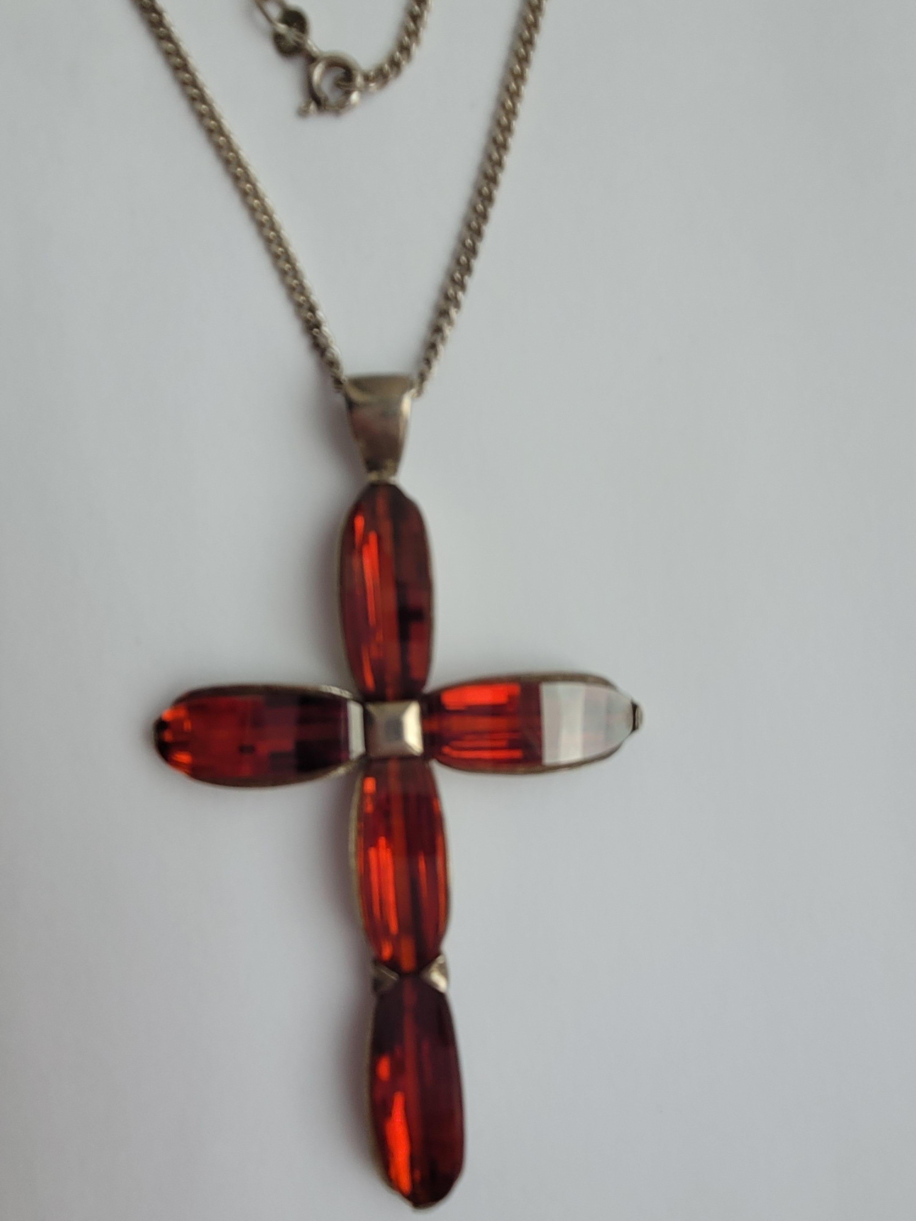 A Stunning and Very Unique Fancy cut bridge shape Hessonite Garnet and solid Sterling Silver large cross pendant on Sterling Silver chain. An impressive and eye-catching necklace.

Total drop of the pendant 71mm, width 43mm.
Length of the chain 49cm
