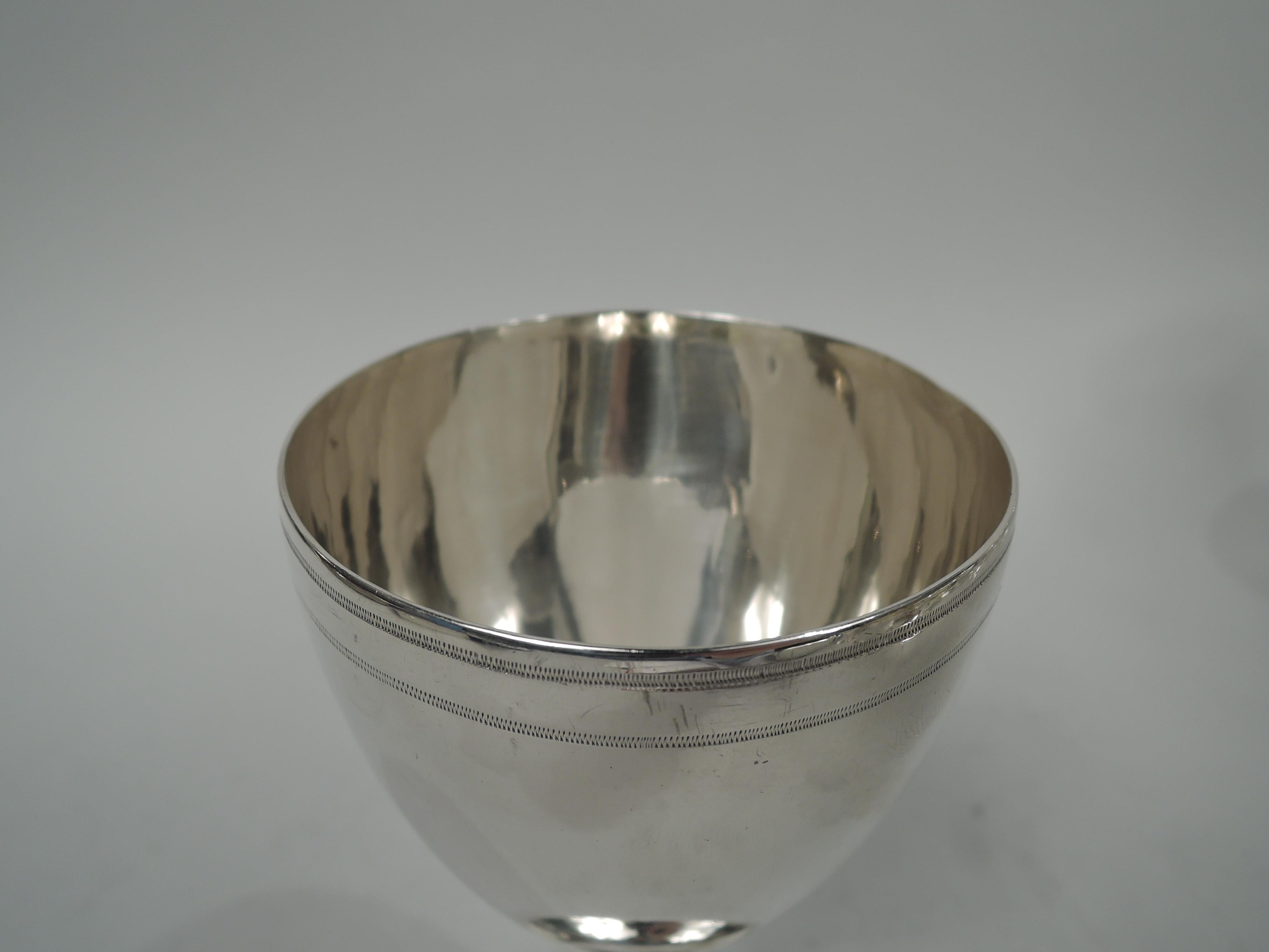 George III sterling silver goblet. Made by Hester Bateman in London in 1785. Ovoid bowl on upward tapering stem flowing into raised foot. Beaded and zigzag borders. Spare Georgian Neoclassicism by a collectible maker. Fully marked. Weight: 5.7 troy