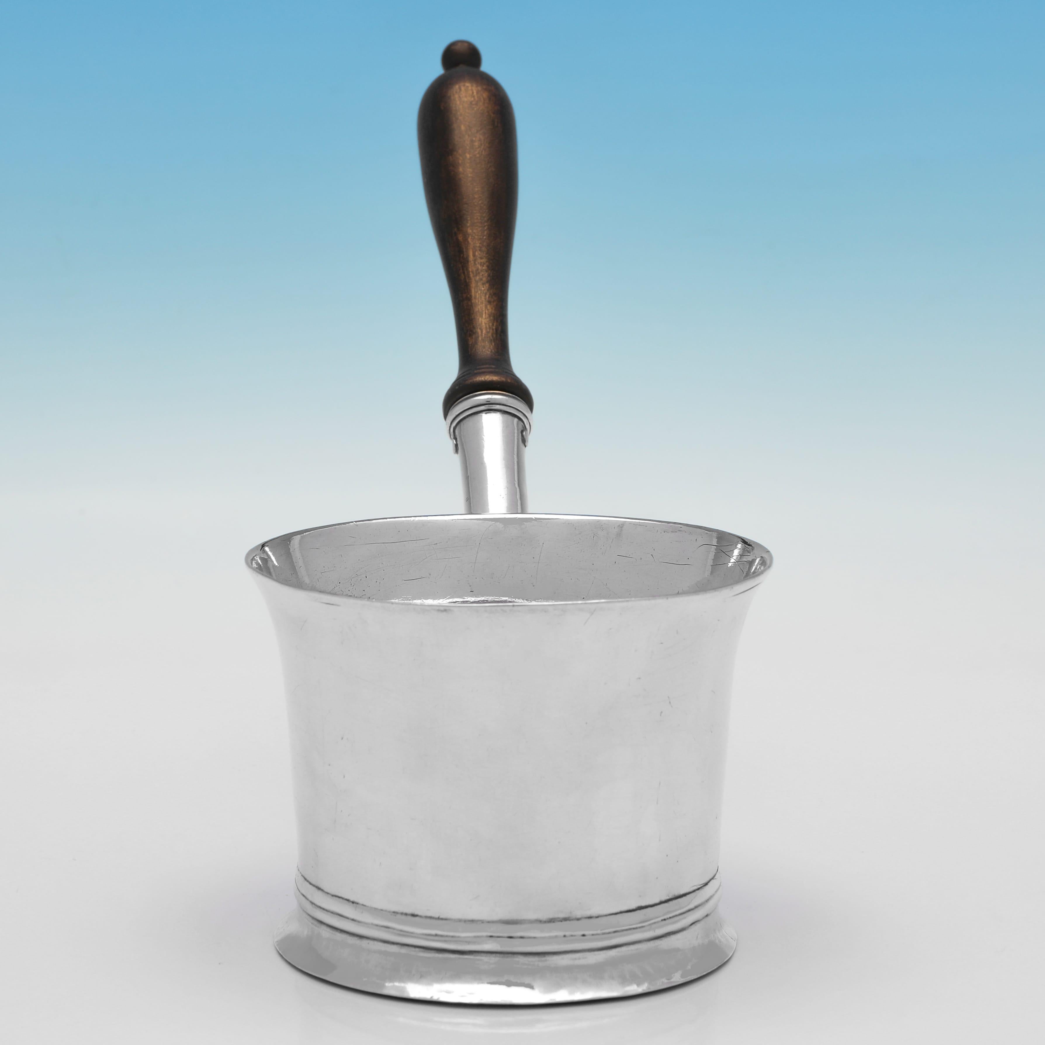 Hallmarked in London in 1785 by Hester Bateman, this handsome, George III, Antique Sterling Silver Brandy Saucepan, is plain in style, featuring reed borders, and a wooden handle. The brandy saucepan measures 6.5