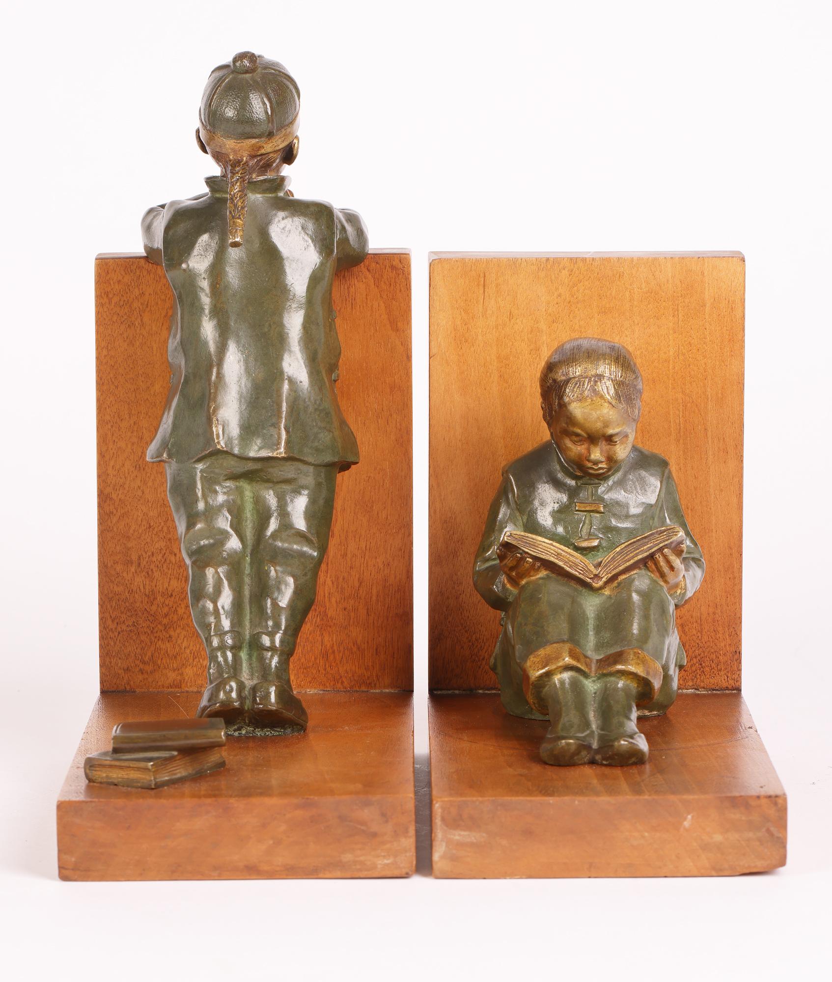 A stunning pair Art Deco cold painted bronze bookends mounted with Oriental Children figures by renowned sculptor Hester Mabel White (British, 1870-1948) and dating from around 1920. This iconic pair of bookends portrays two children in Oriental