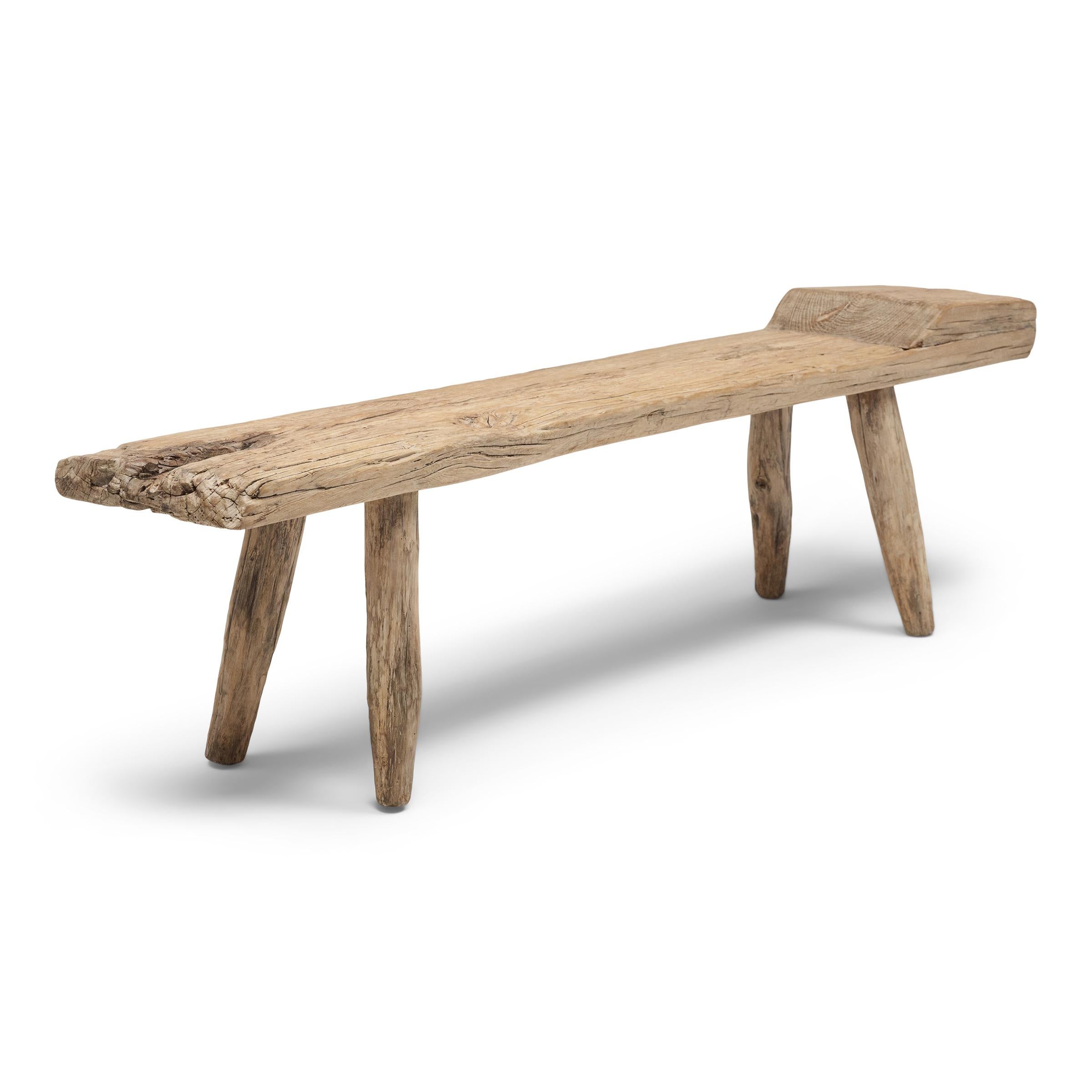 This low courtyard bench from Shandong province embodies the spirit of wabi-sabi, the Japanese philosophy that beauty and integrity can be found within the imperfections of a timeworn object. The plank top seat is comprised of a single timber of