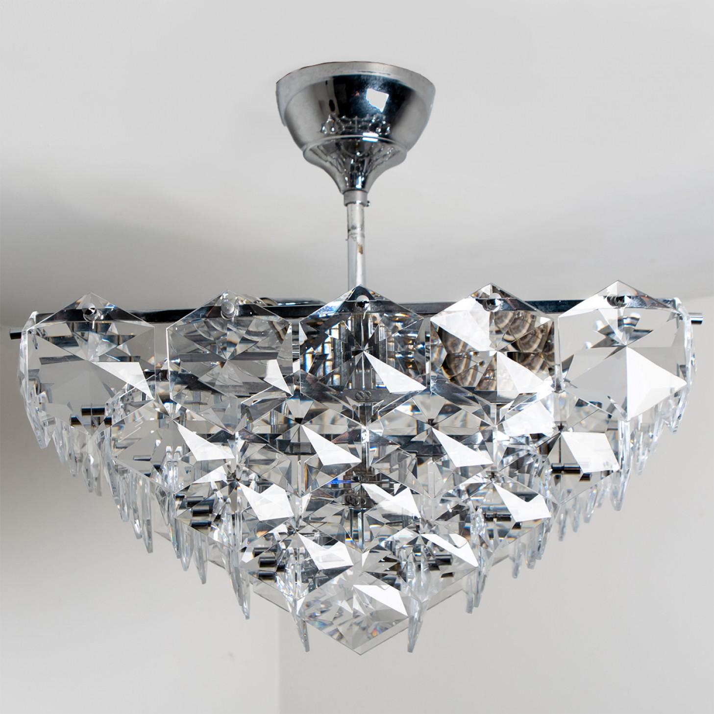This modernist design chrome chandelier was designed by the Kinkeldey design team during the 1970s and manufactured in Germany. A very elegant Kinkeldey chandelier, it is comfortable with all decor periods. The crystals are meticulously cut in such