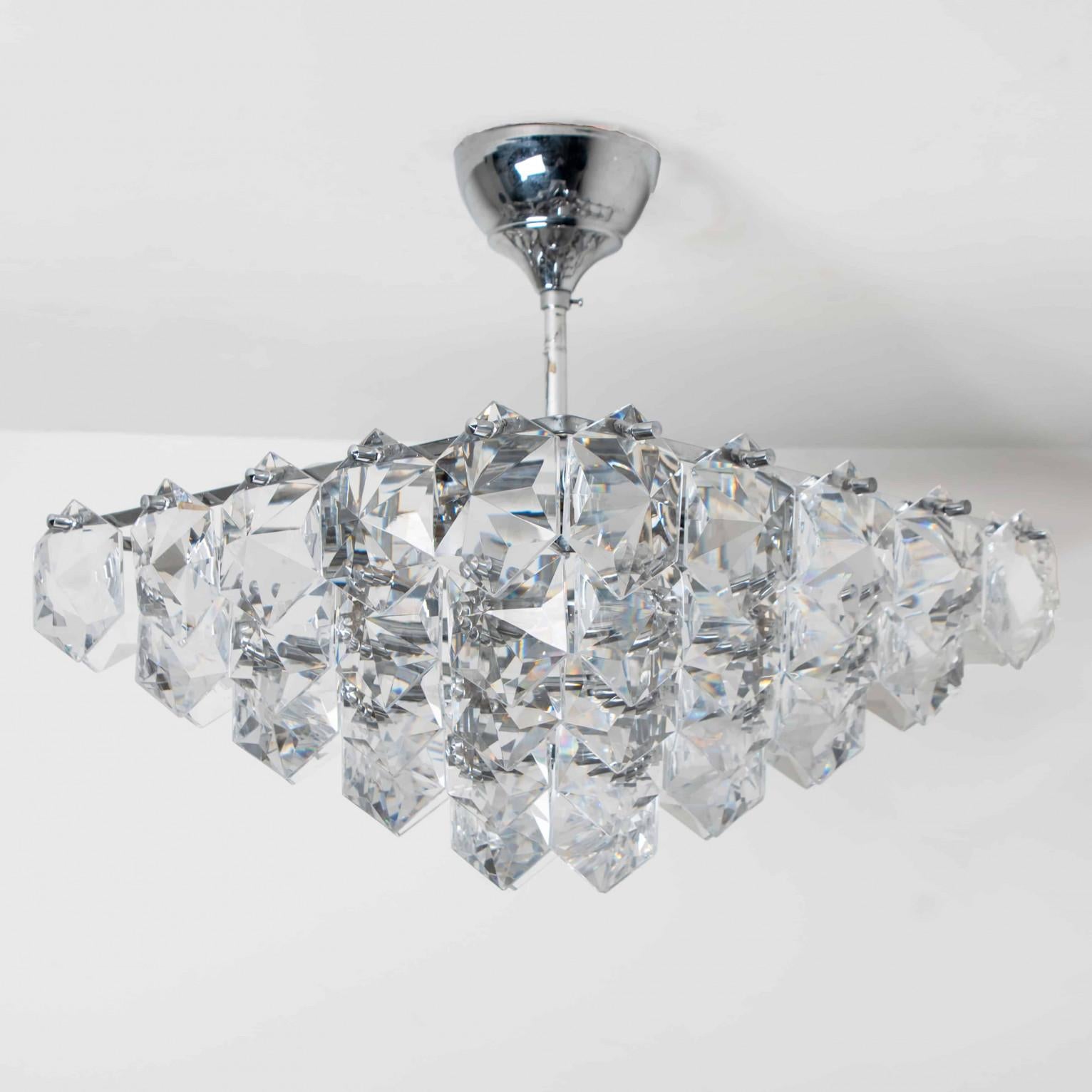 Dieser verchromte Kronleuchter im modernistischen Design wurde in den 1970er Jahren vom Designteam Kinkeldey entworfen und in Deutschland hergestellt. Ein sehr eleganter Kinkeldey-Kronleuchter, der zu allen Einrichtungsstilen passt. Die Kristalle