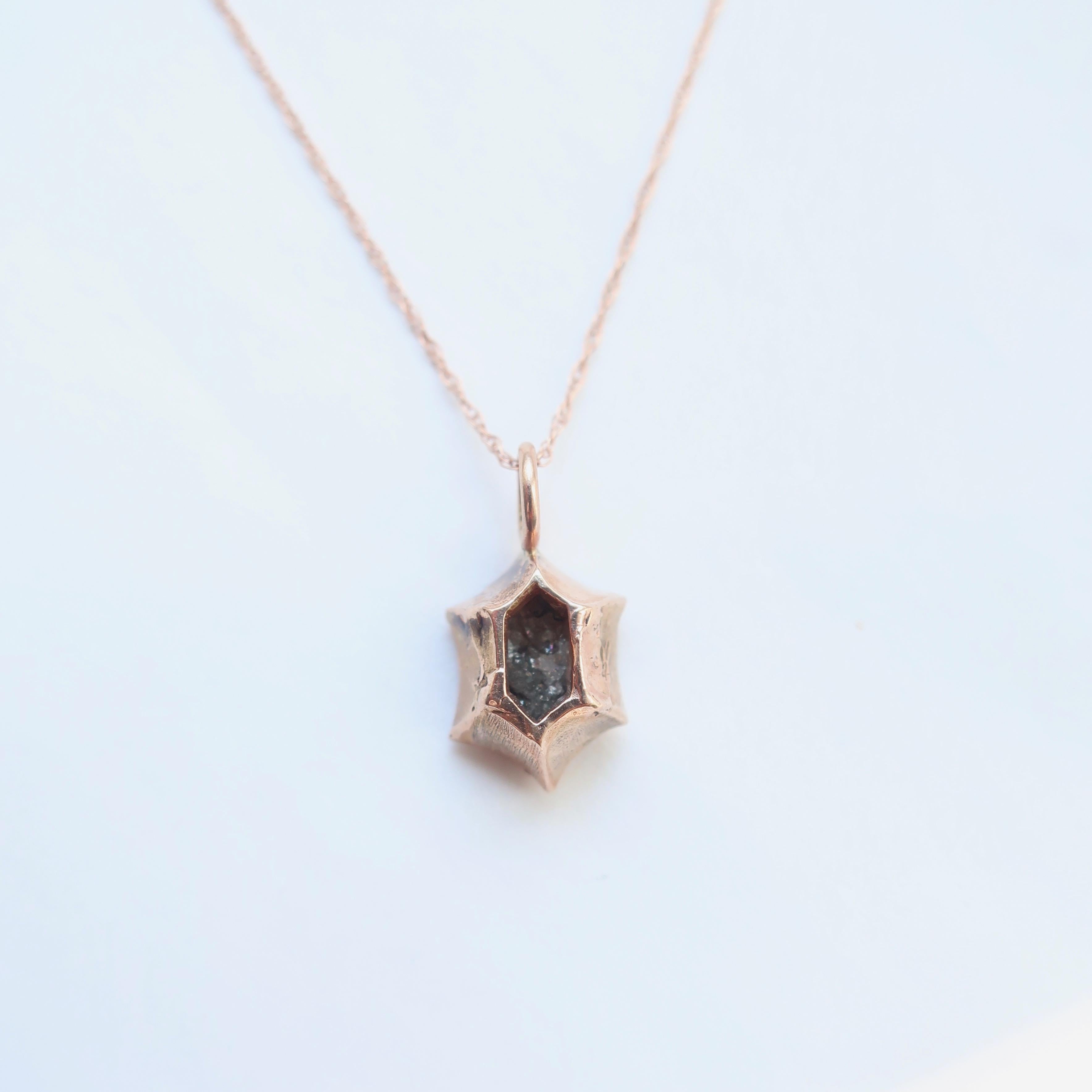 A rustic brown rosecut diamond set in a 14k rose gold setting on an 18 inch gold chain. This is a delicate piece perfect for everyday wear. The diamond measures 7.3 mm in length and weighs 1.10 carats. This piece is hand carved and the sides concave