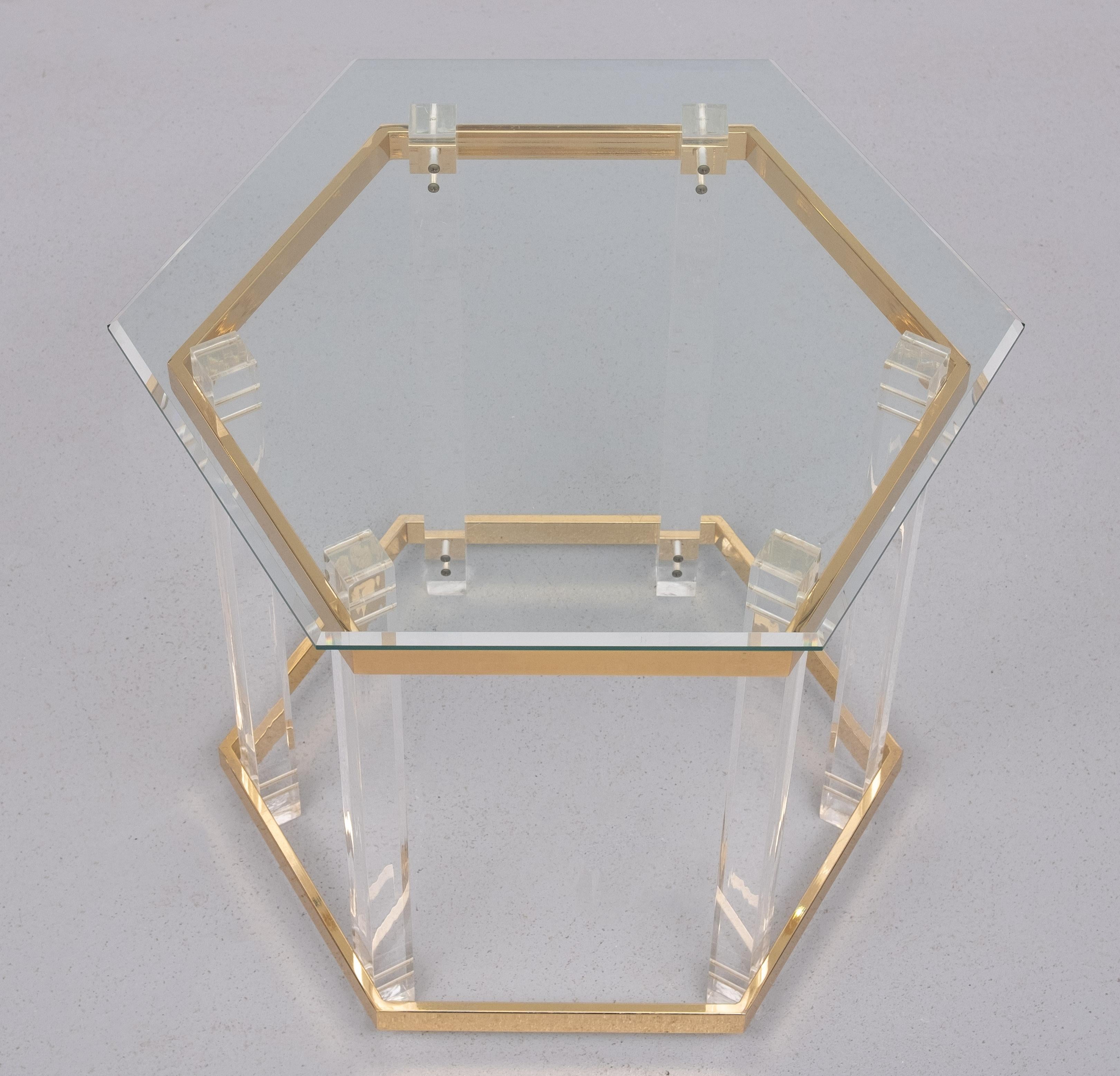 Hexagon shaped side or sofa or small Coffee table Hollywood Regency 1970s Lucite legs Brass spanners ,comes with the original thick beveled 
Glass top . Beautiful table , comes with the normal wear and tear after 
50 years .