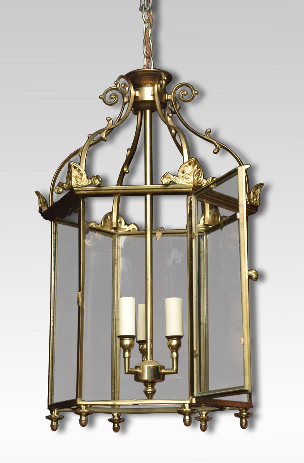 Hexagonal brass hall lantern of George III style with six scrolled ribs and glazed panels enclosing three lights. The lantern has been rewired.
Dimensions:
Height 15 inches
Width 15 inches
Depth 15 inches.