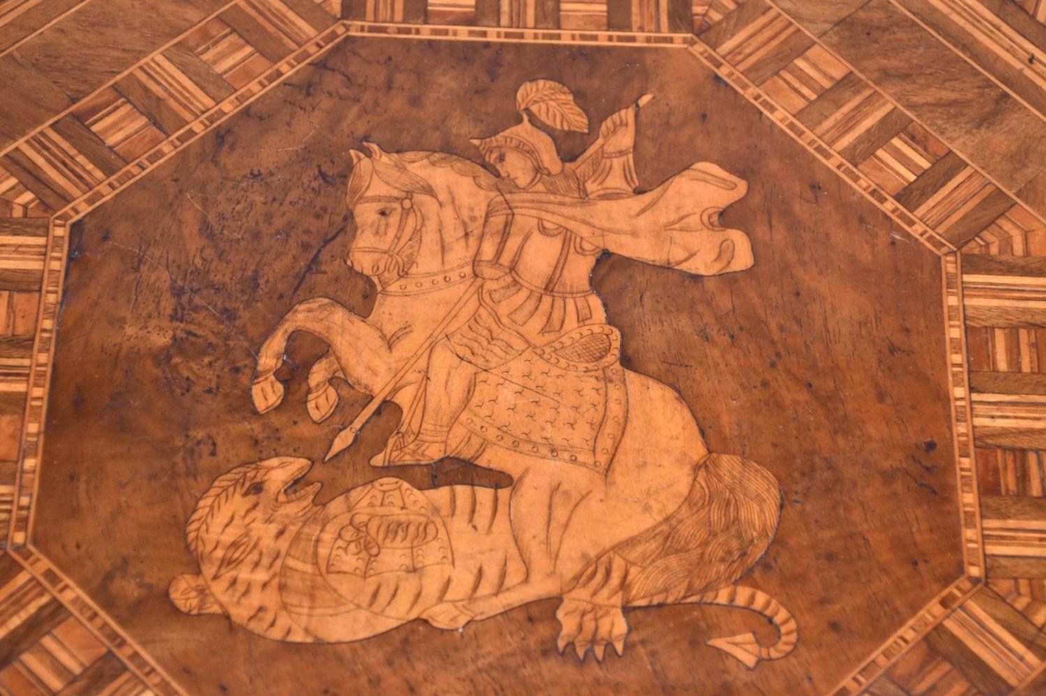 19th Century hexagonal shaped center table with Marquetry surface. Marquetry inlay features a knight on horseback with spear, fighting off a medieval animal. Table sits on a turned stem pedestal base resting on three scrolled legs. A 19th century