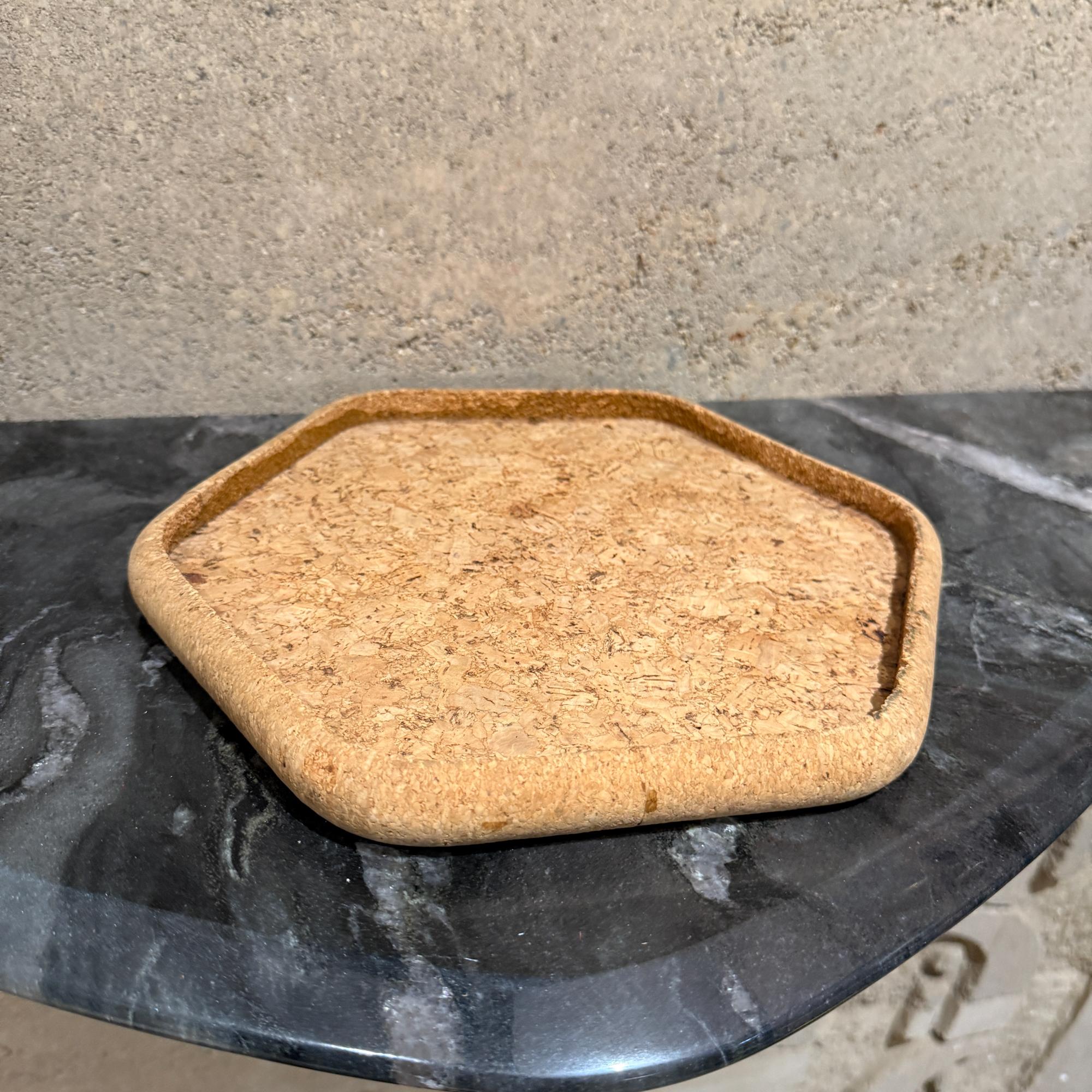 Pour votre considération, un sous-verre hexagonal en liège ou un petit plateau. Sa fonction première est de protéger les surfaces telles que les tables et les comptoirs de la chaleur, des rayures et des auréoles d'humidité causées par les boissons