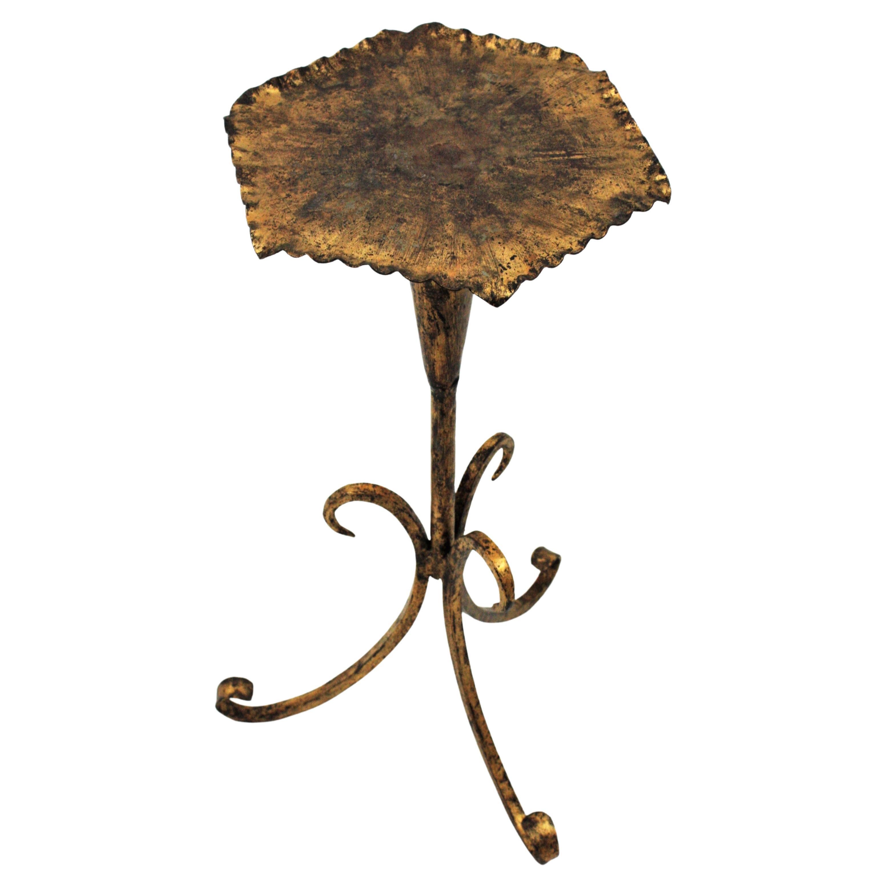 Eye-catching gilt hand forged iron hexagon side or end table. Spain, 1940s.
This beautiful Martini table features an hexagon top with twisted iron edge standing on a tripod base with scroll details. This table is entirely made by hand in wrought