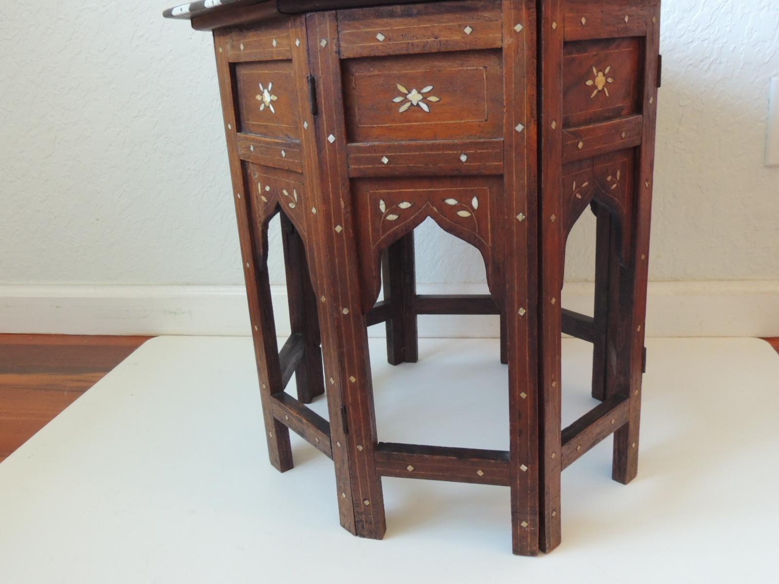 Hexagonal folding hand carved bone inlaid Indian side table.
The top fits onto the base but is not even..
Some camel bone missing from top and edges, some discoloration.
Great patina and look.
The base is in excellent conditions.
Sold as