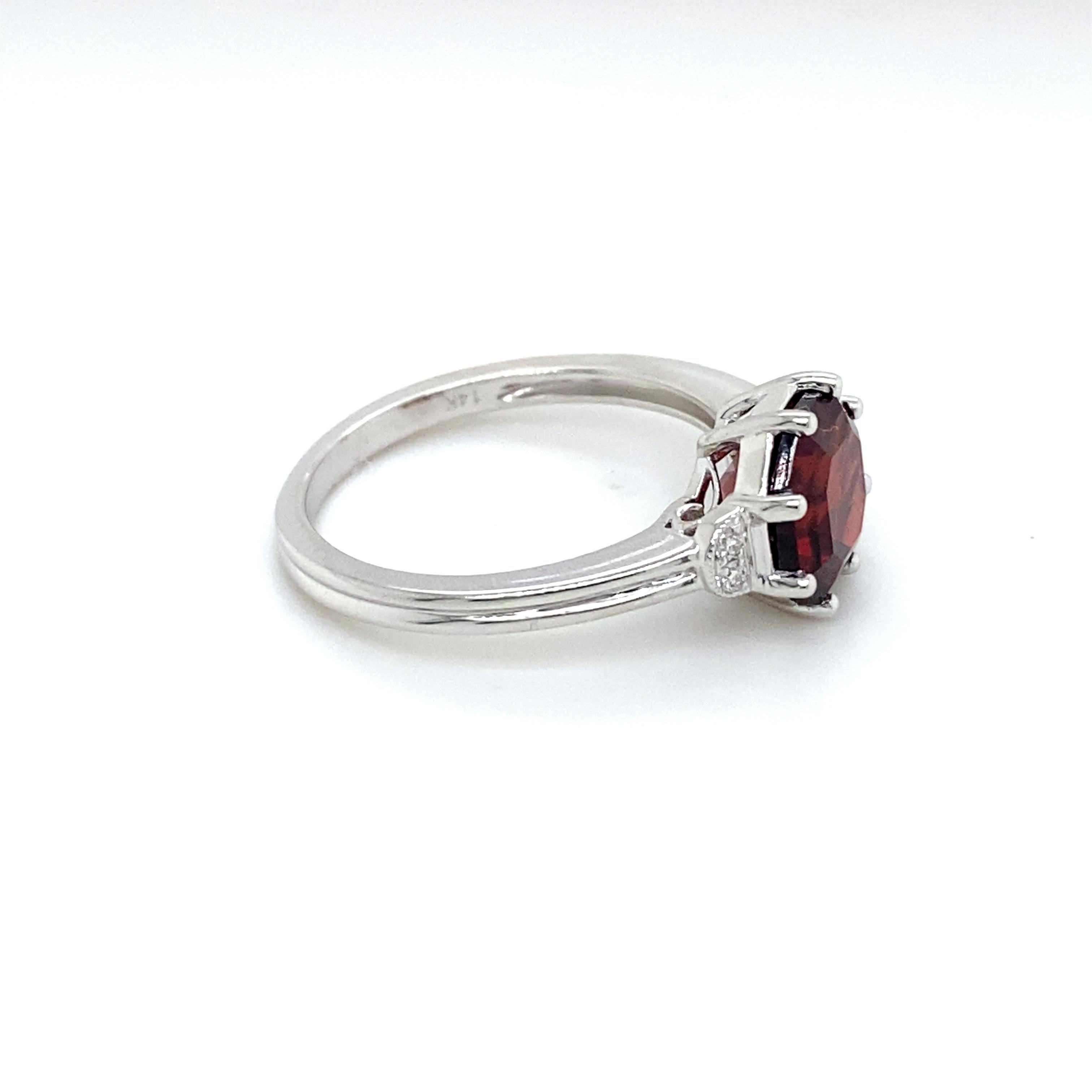 This three stone ring is a unique design! The garnet is cut in a hexagonal faceted design and is elegant with a diamond on either side. If you love the color red, you will love this ring. The ring is constructed out of solid 14 karat white gold