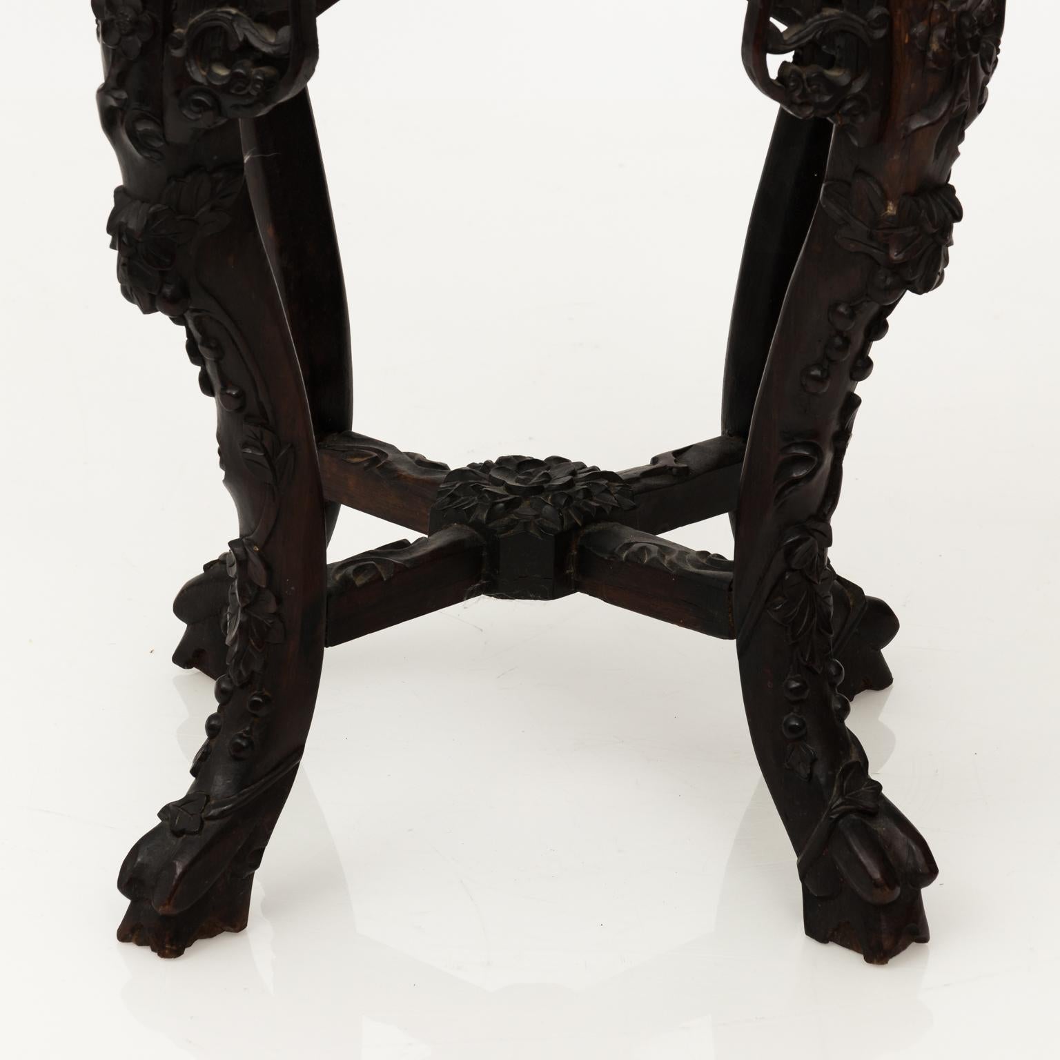 Hexagonal marble-top Chinese export side table with heavily carved dragons and foliage throughout. The base also features cabriole legs, a cross stretcher, and lion's paw feet.
 