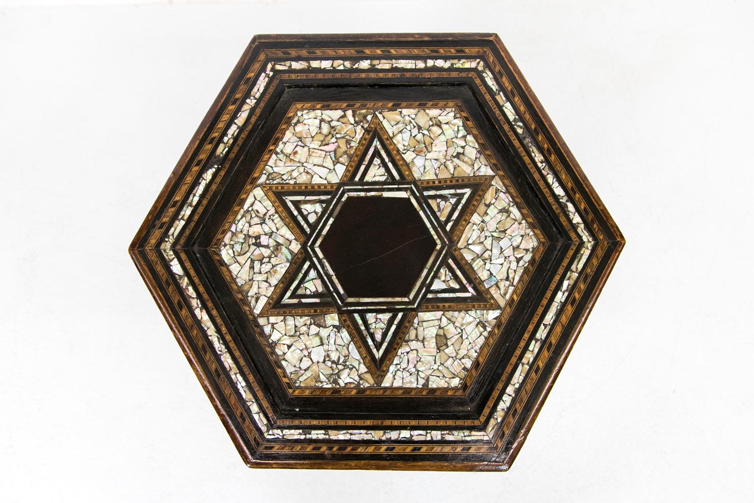Sechseckiger marokkanischer Tisch mit Intarsienarbeit. Die Platte ist mit einem Mosaik aus Ebenholz und Abalone-Muscheln eingelegt und mit verschiedenen exotischen Hölzern belegt.


 